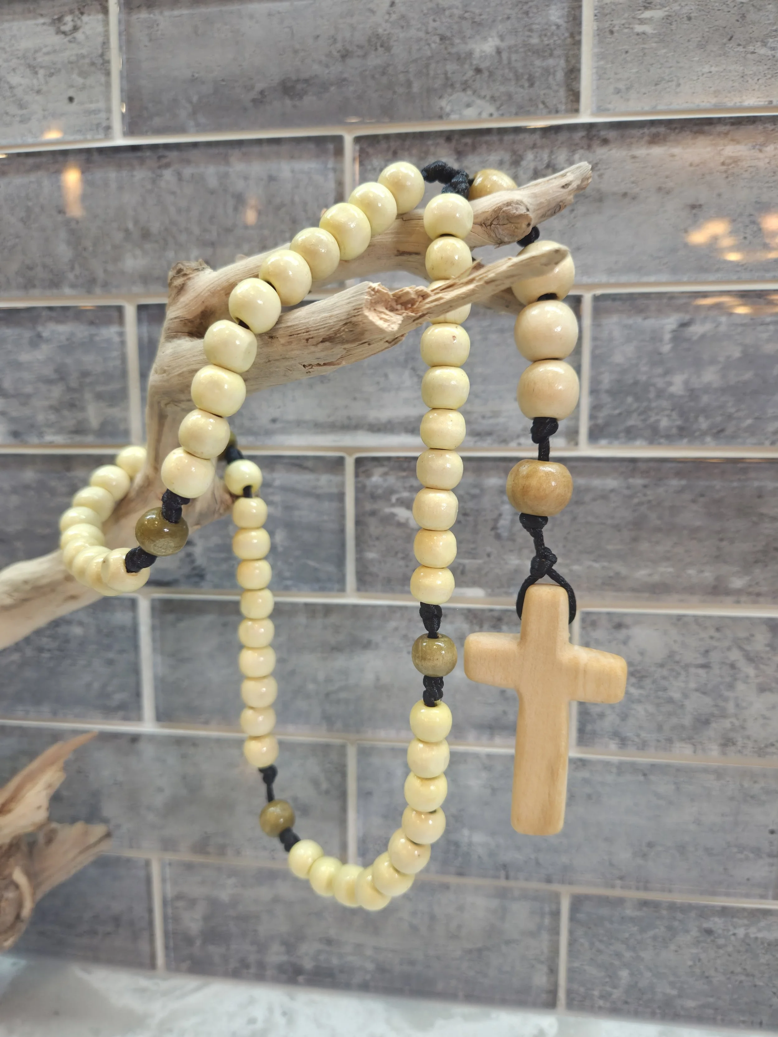 handmade wooden rosary on top of wooden branch