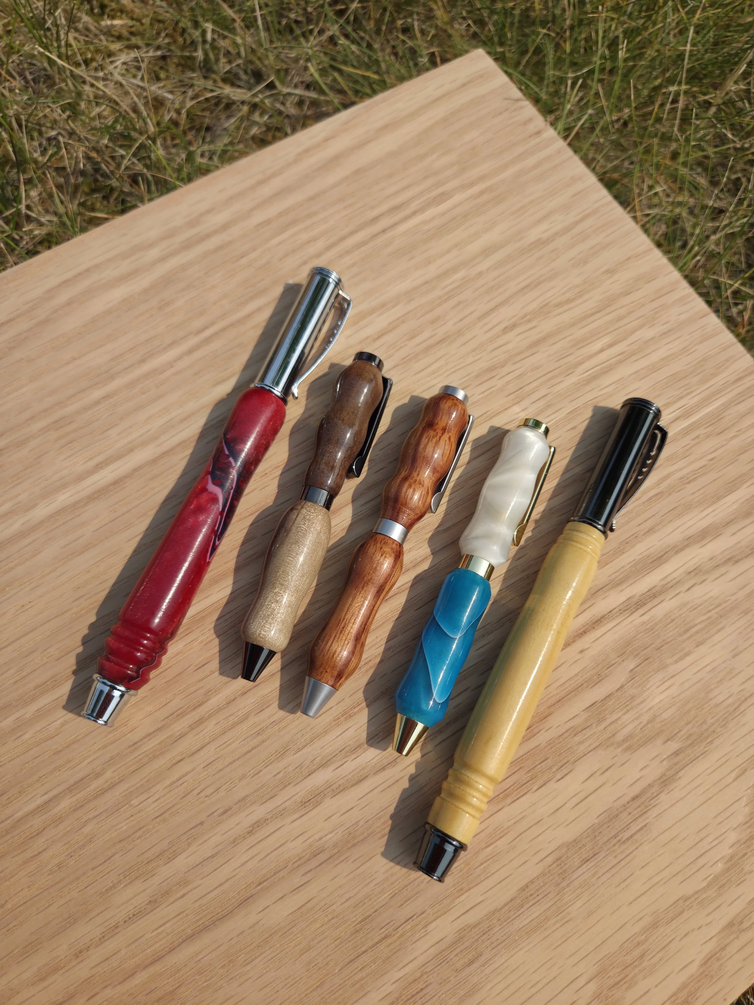 Five handmade turned pens both wooden and acrylic of various sizes 