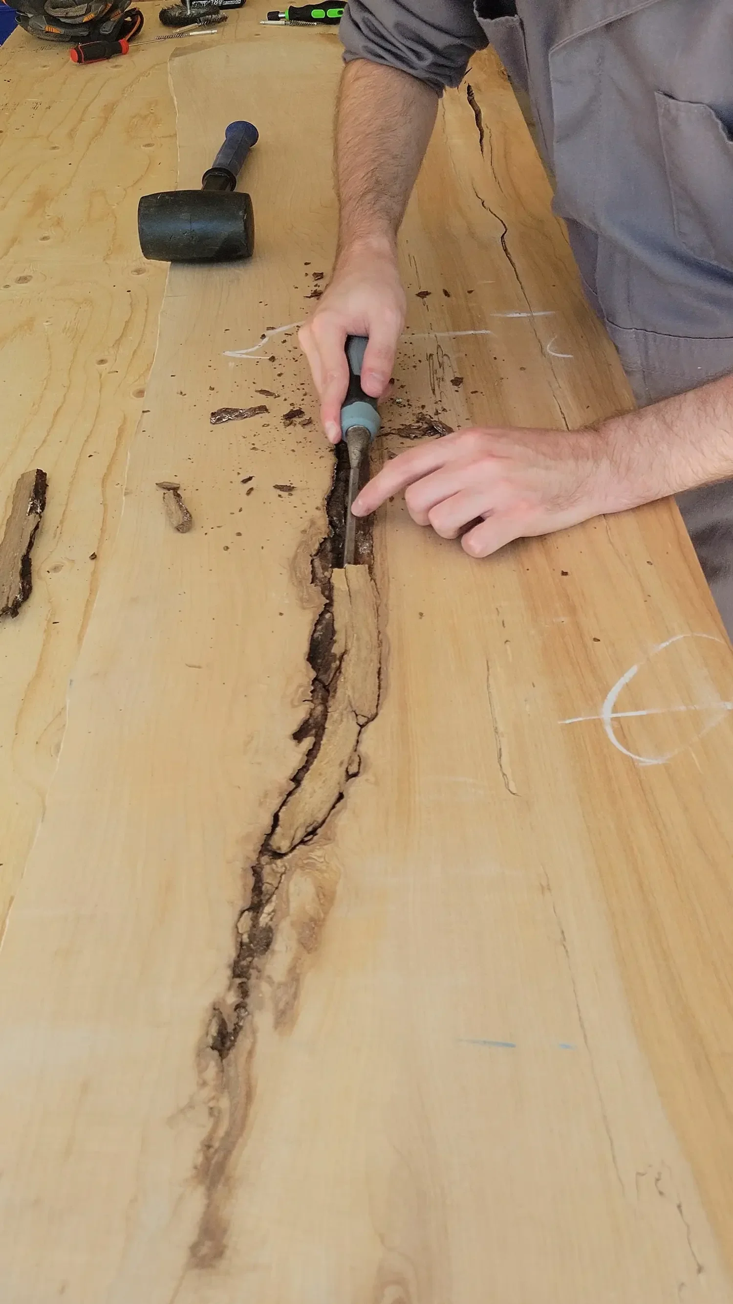 using a chisel to clean the bark out for an epoxy pour