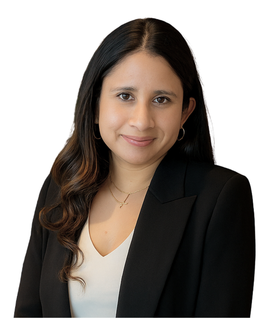 A woman in a black blazer stands smiling in front of wooden shelves filled with books and decorative items. She exudes a professional and friendly demeanor.