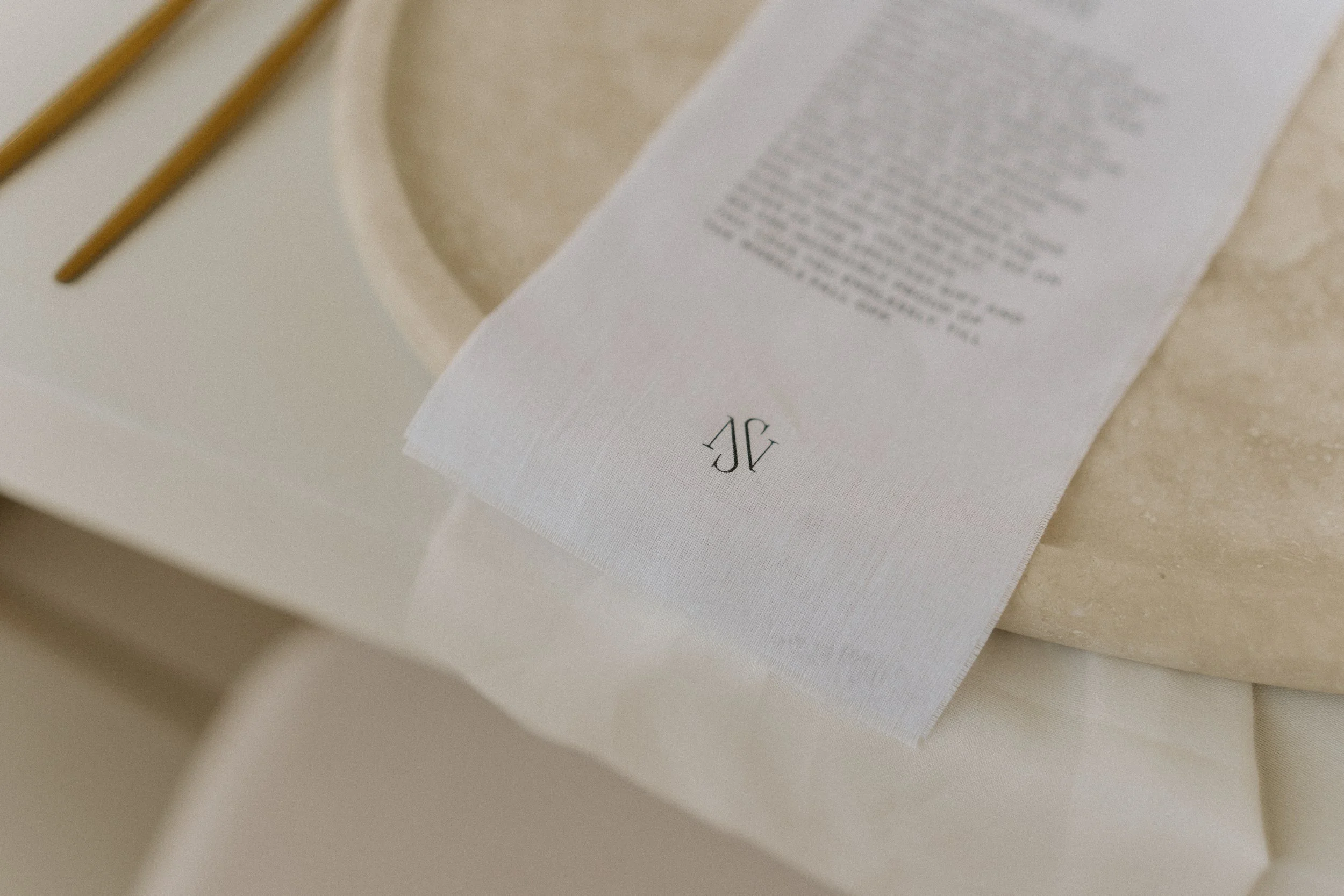 Wedding and event linen fabric dinner menu with custom couple name monogram in white with black text as table setting
