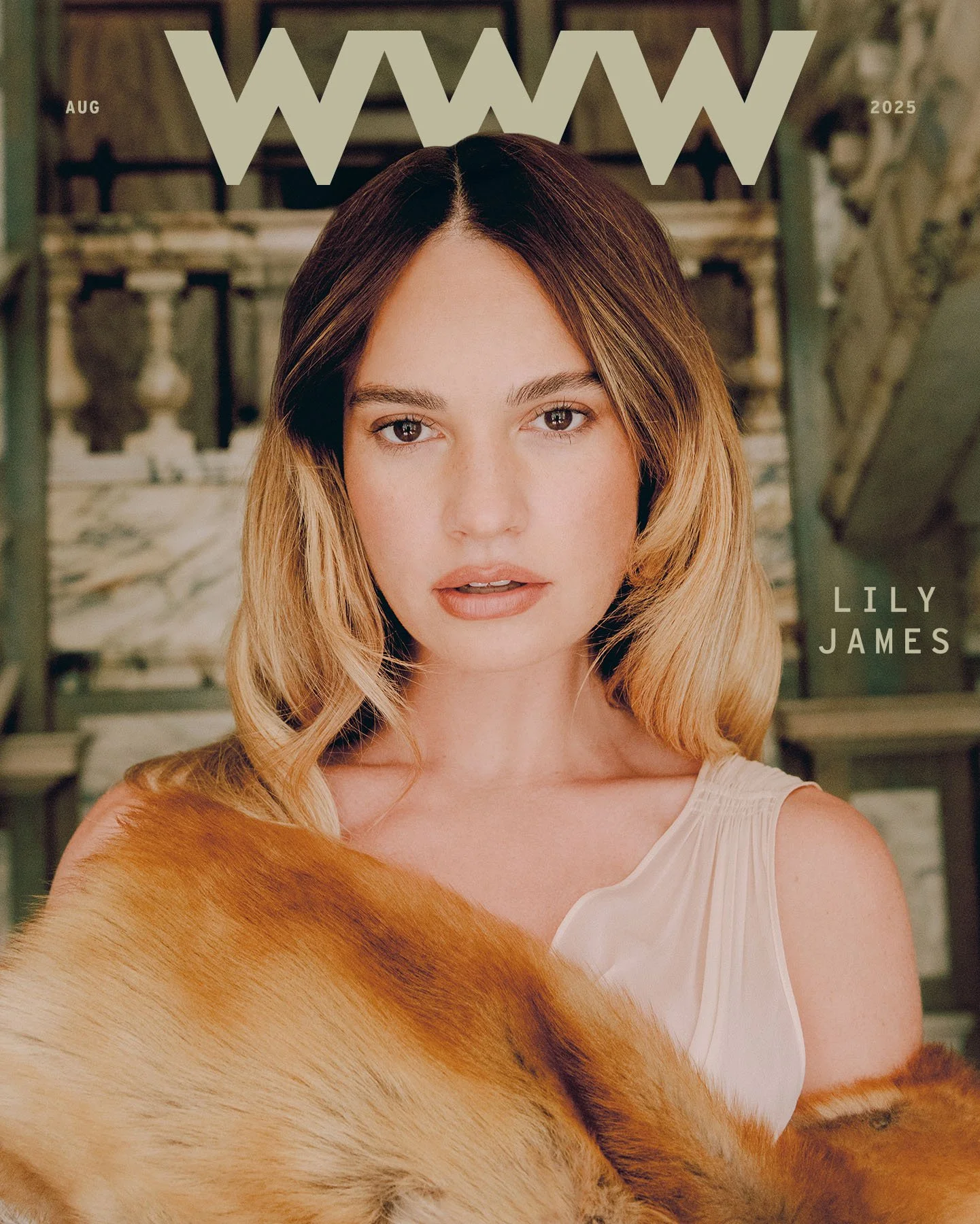 Cover of WOW magazine featuring Lily James with her hair styled in loose waves, wearing a white top and a fur stole, with a blurred indoor background.