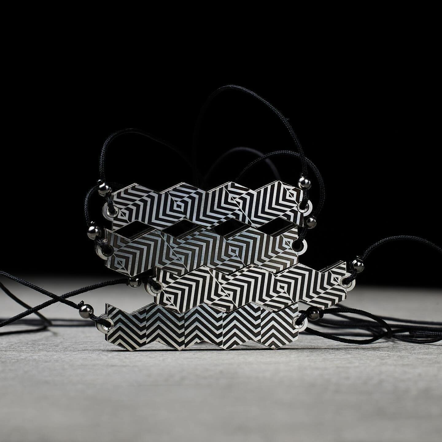 LISTEN,
silver pendants (8mmx40mm)

Their faces are engraved with zebra-like dazzle camouflage patterns, of the type first used in the First World War to protect ships from torpedo attacks. The idea was not to conceal the target, as a battleship grey