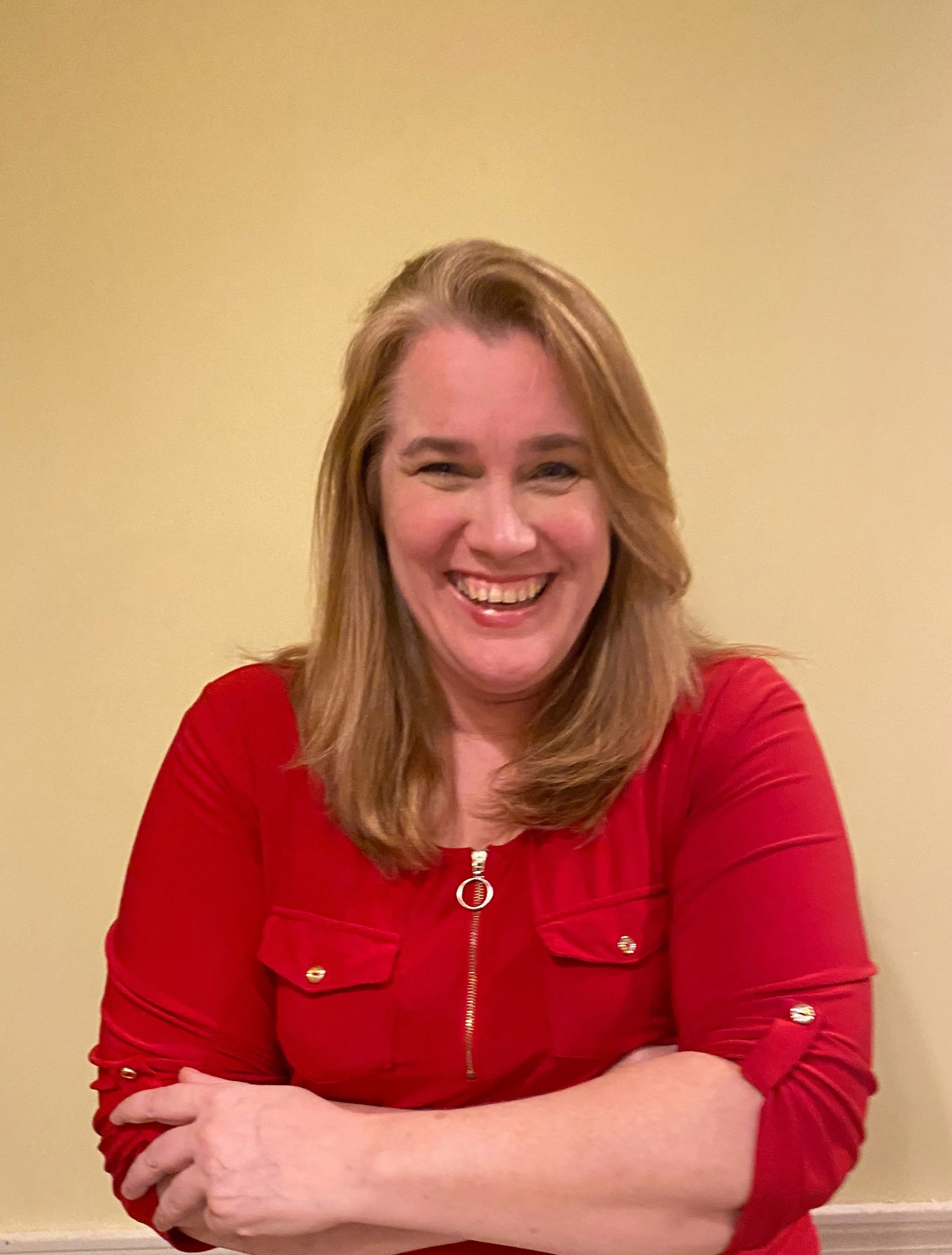 Tanya Lynch, professional genealogist and founder of Teach Me My Tree, smiling warmly in a red shirt.