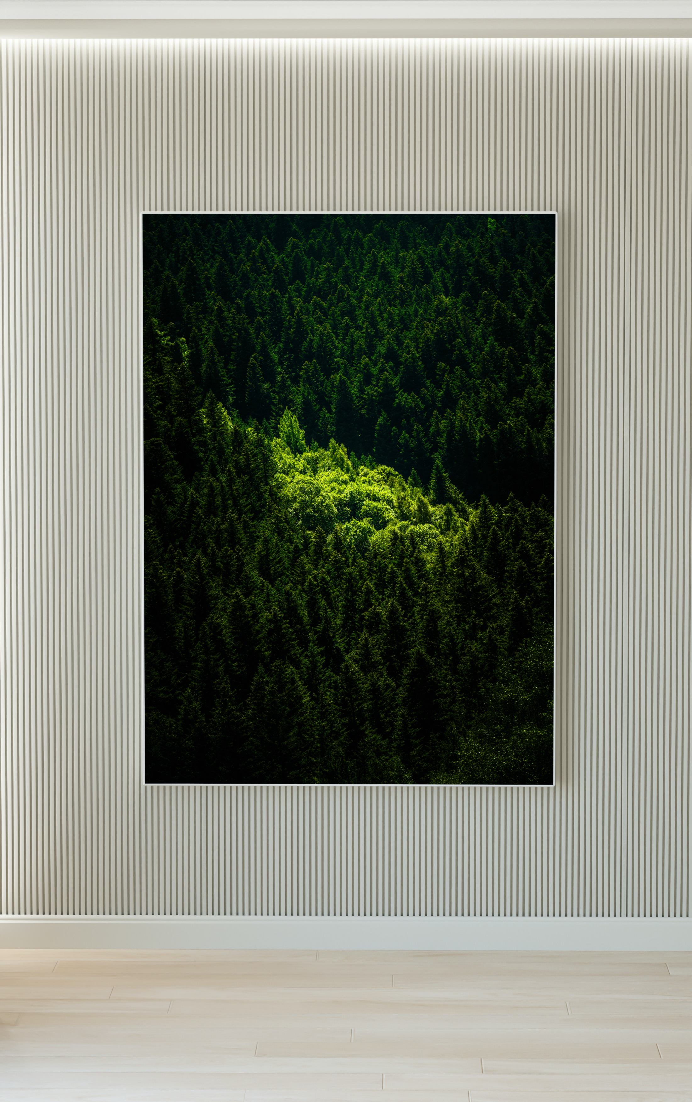 Cuadro con imagen de un bosque denso y verde, colgado en una pared blanca de rayas verticales en una sala moderna.
