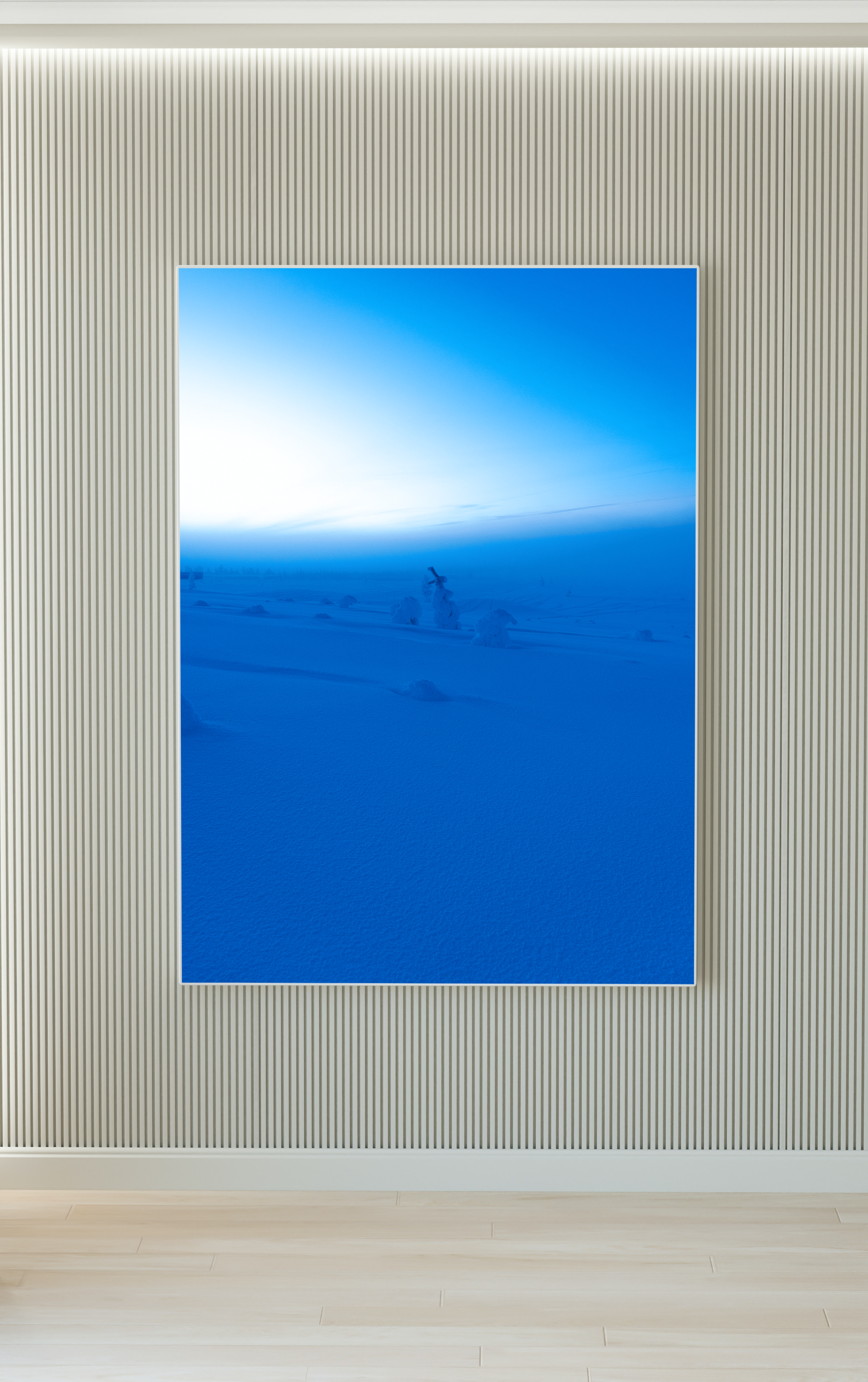 Una pintura o fotografía de un paisaje nevado con árboles cubiertos de nieve y un cielo azul claro, enmarcada y colgada en una pared decorativa de color beige con textura vertical.