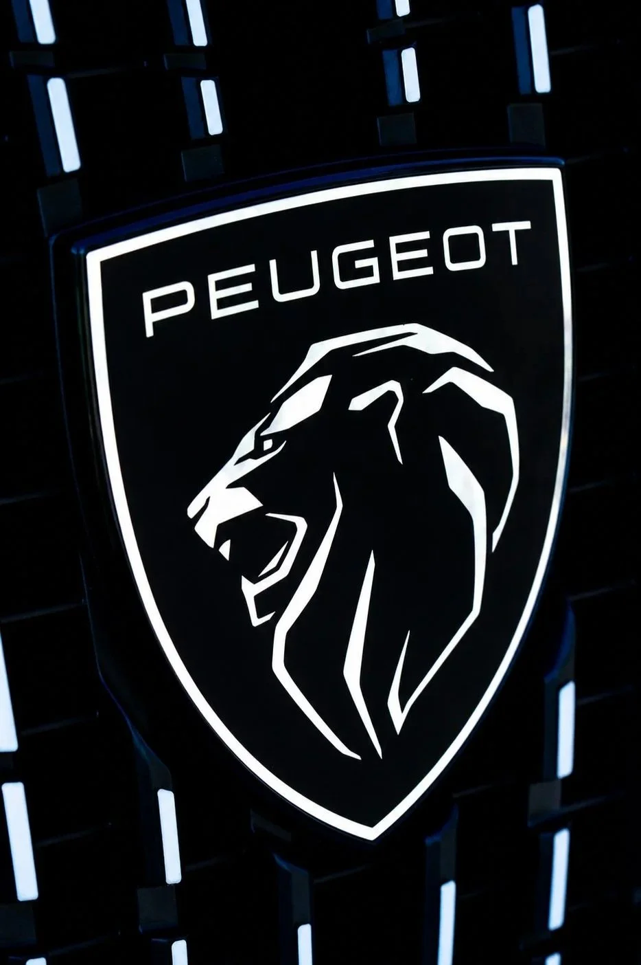 Escudo de Peugeot con un león en color blanco sobre fondo negro, con iluminación LED.