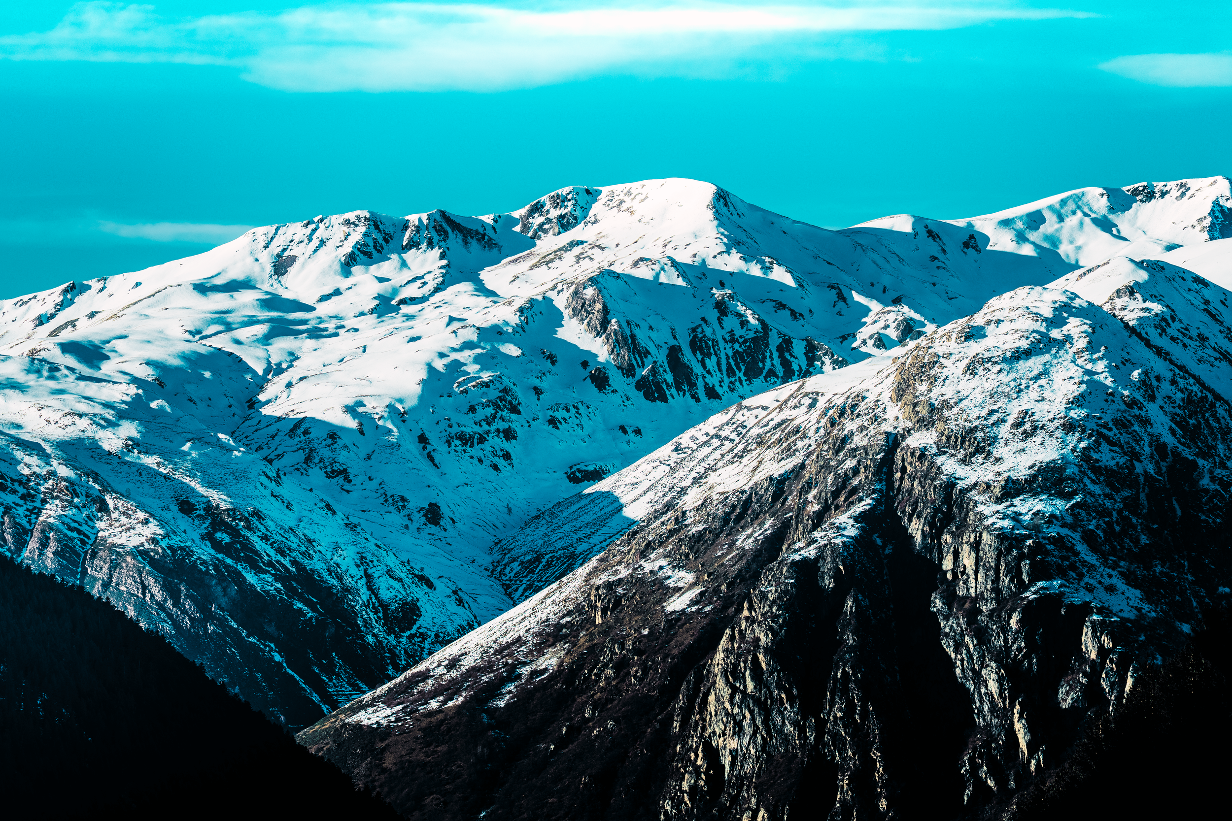 Montañas con picos cubiertos de nieve y cielo azul.