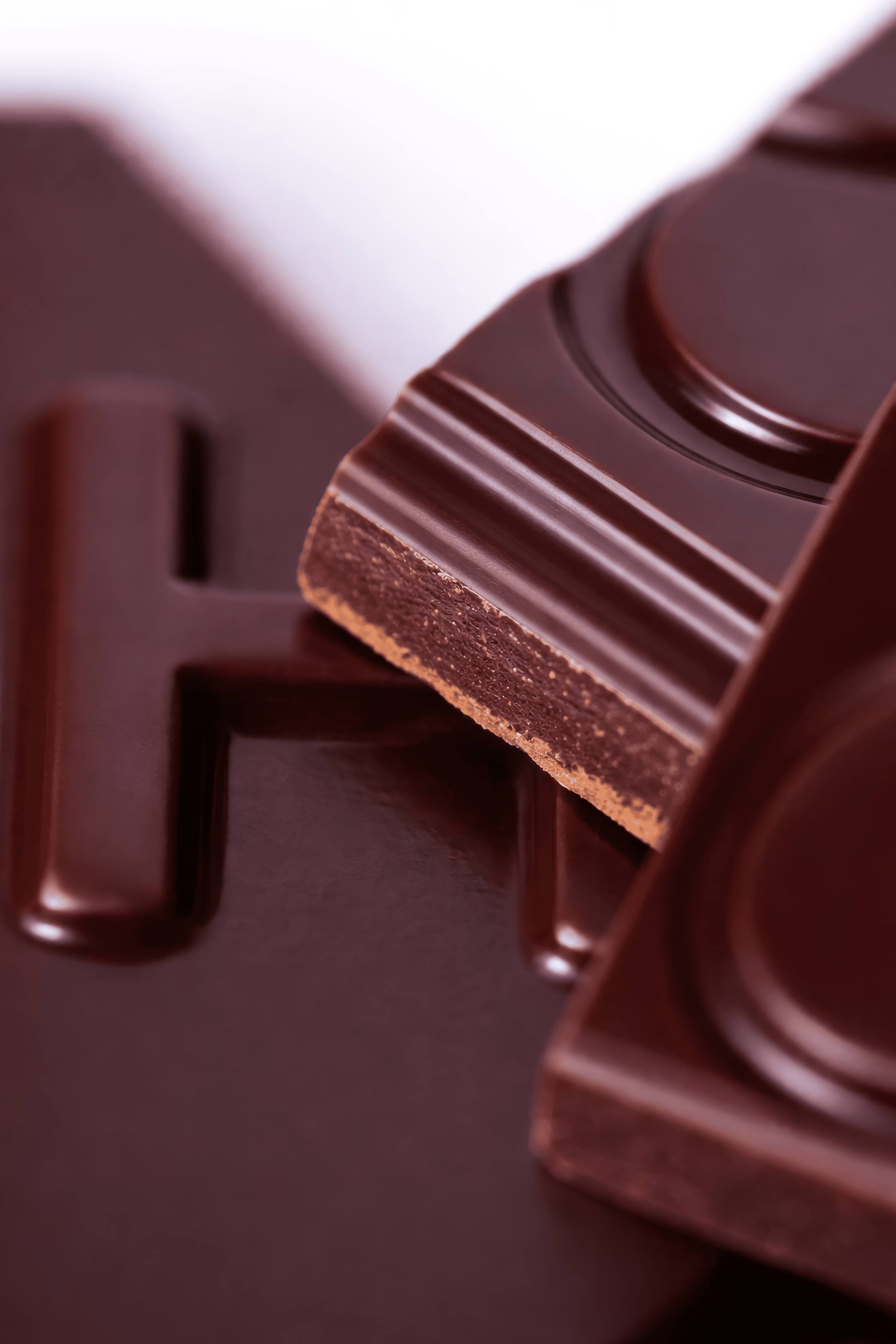 Barra de chocolate con una rebanada partida en primer plano.