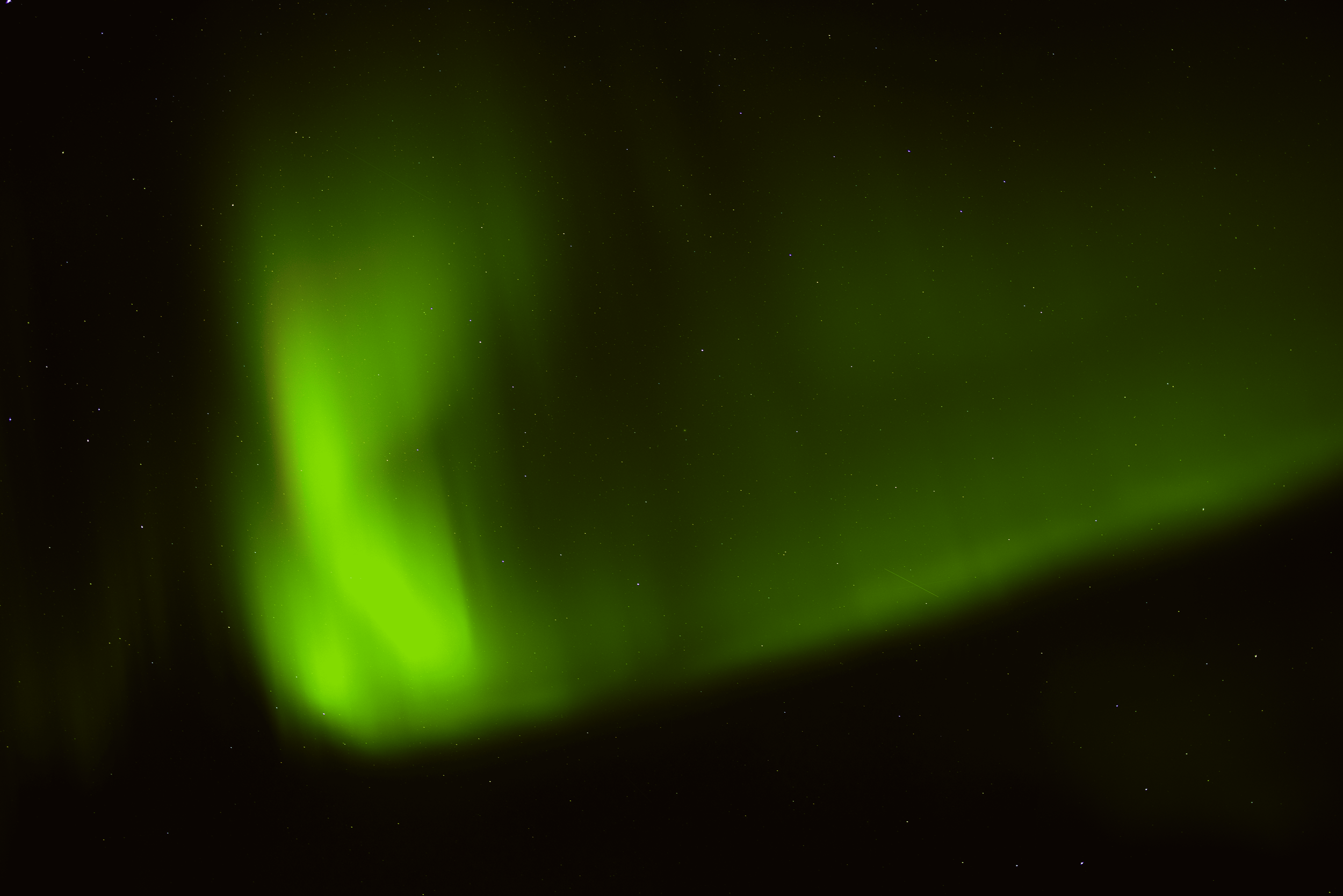 Aurora boreal verde en un cielo estrellado.