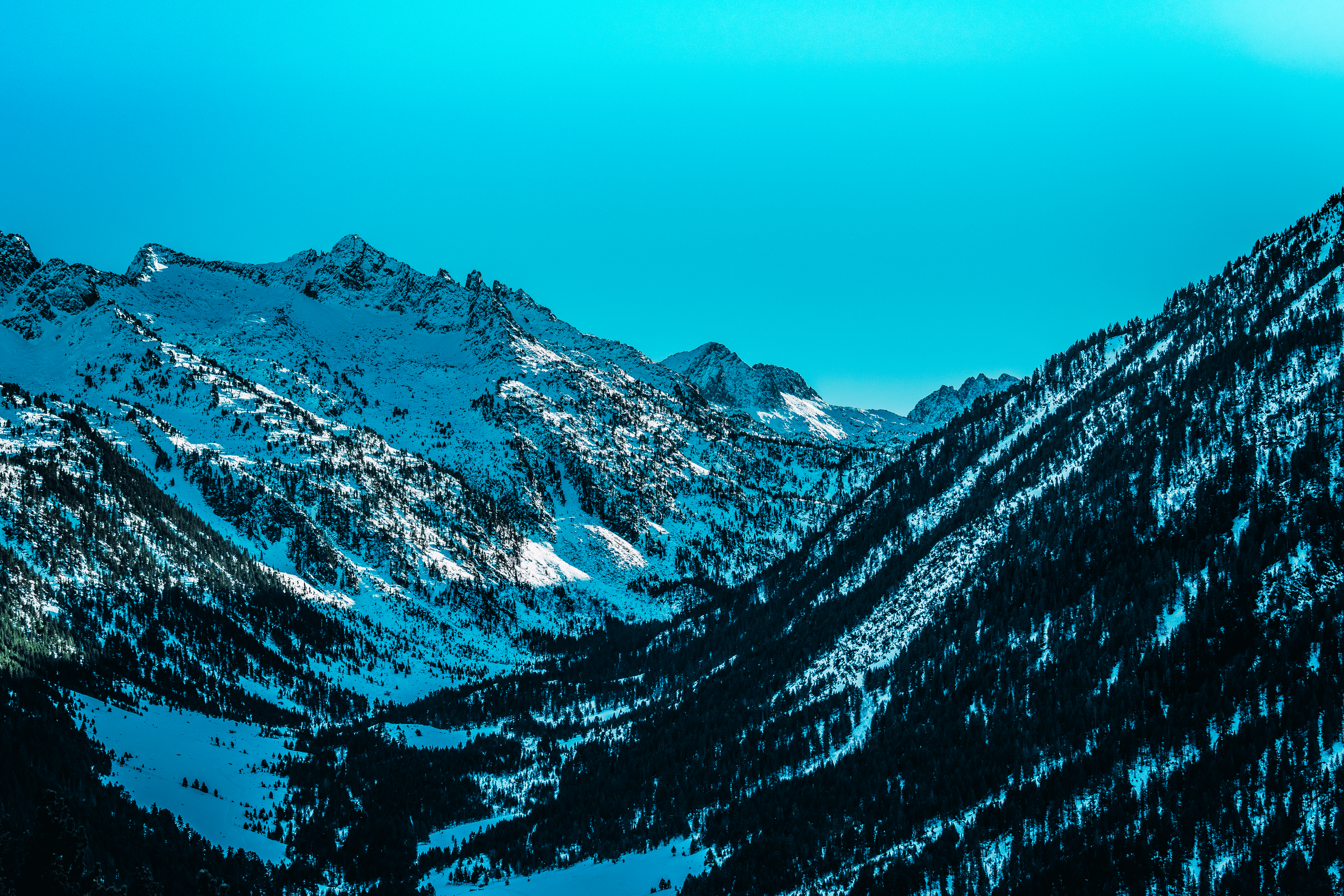 Montañas cubiertas de nieve con un cielo azul claro.