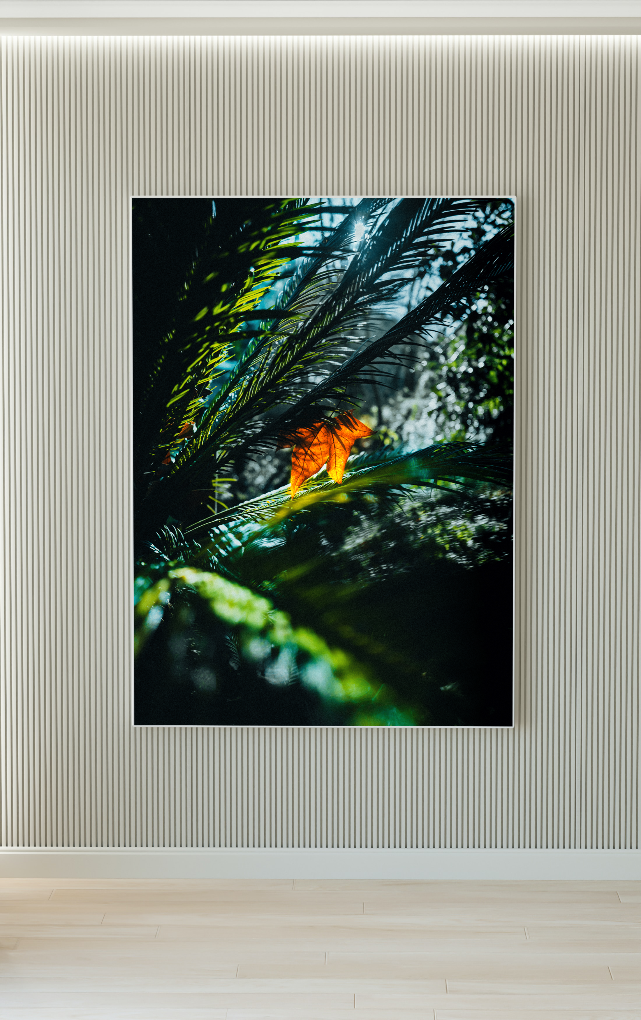 Fotografía de una hoja naranja entre follaje verde y sombras.