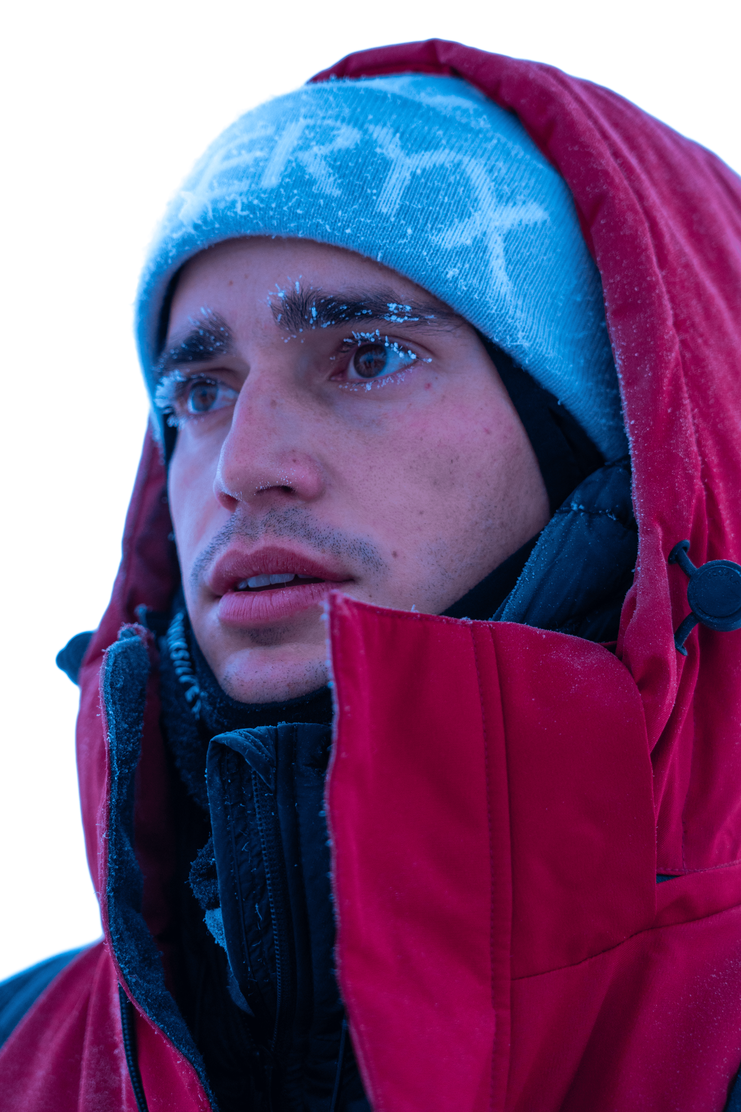 Joven con ropa de abrigo en clima frío, con nieve en su barba y cejas.
