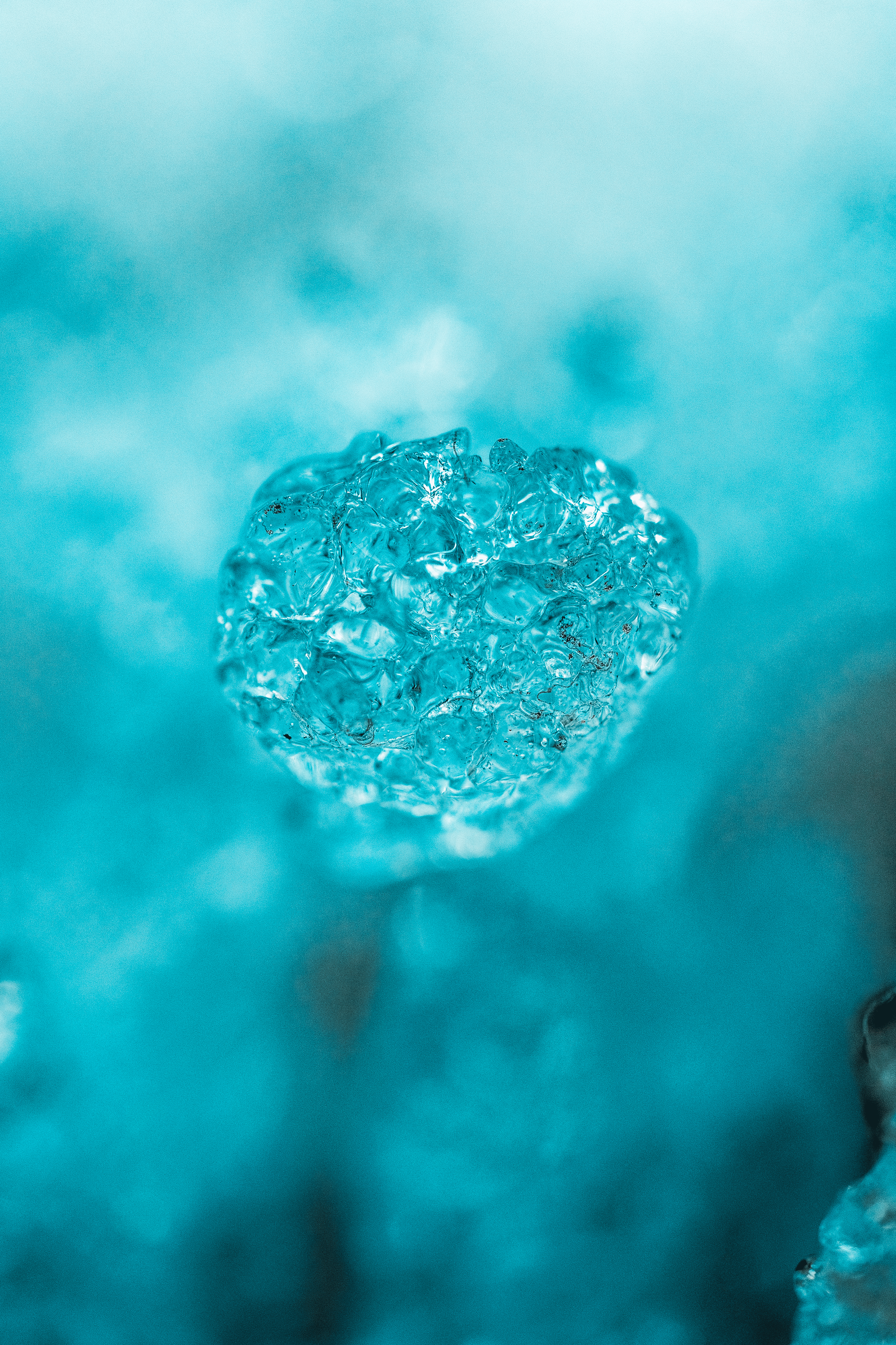 Una gota de agua cristalina en forma de corazón con un fondo desenfocado en tonos azules.