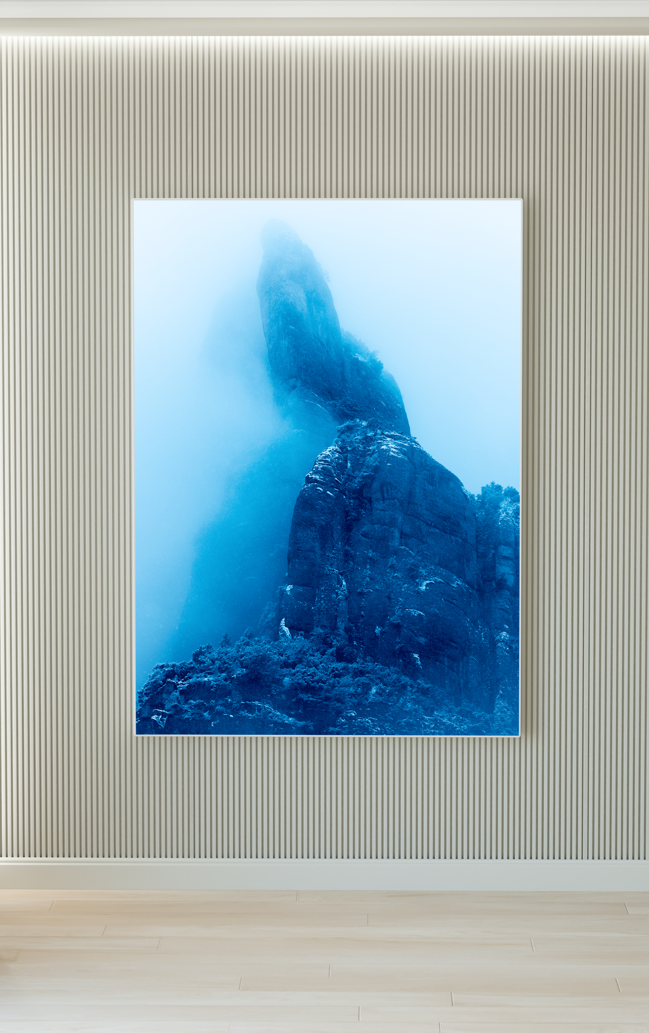 Montaña rocosa envuelta en niebla, vista desde un interior con paredes de madera y marco blanco.