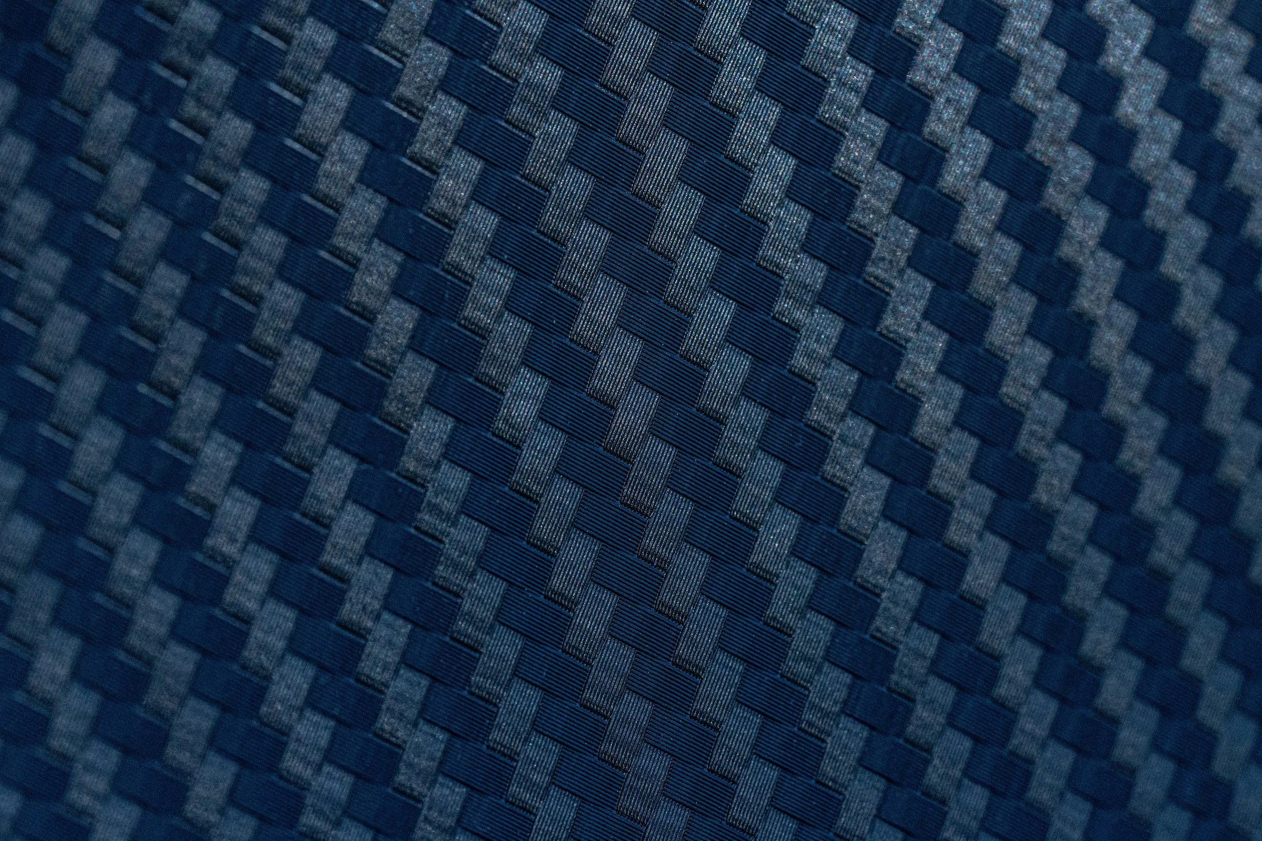 Superficie de tela de color azul con patrón de cuadros y líneas finas entrelazadas.