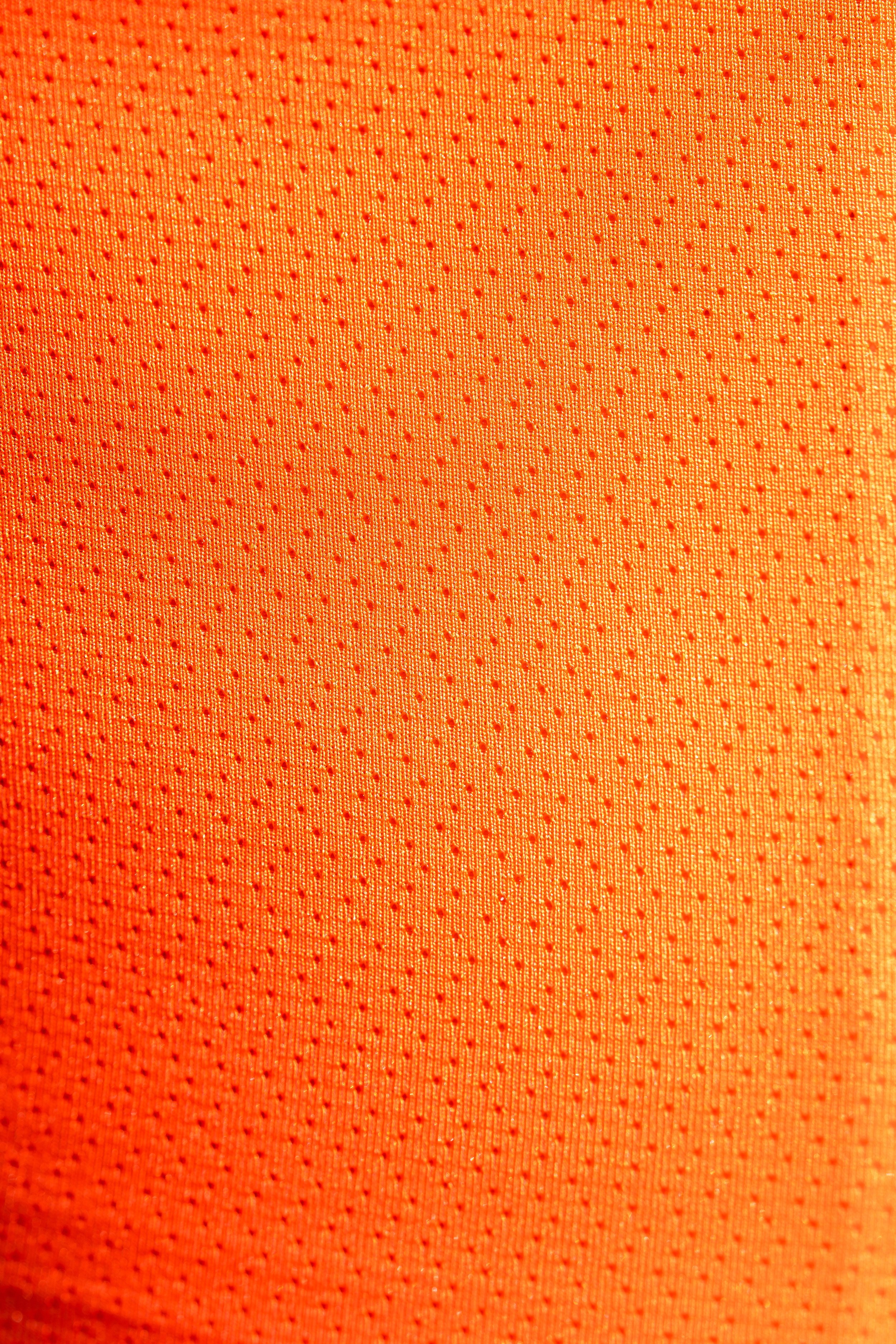 Texto en una superficie naranja con textura de puntos pequeños y líneas paralelas.