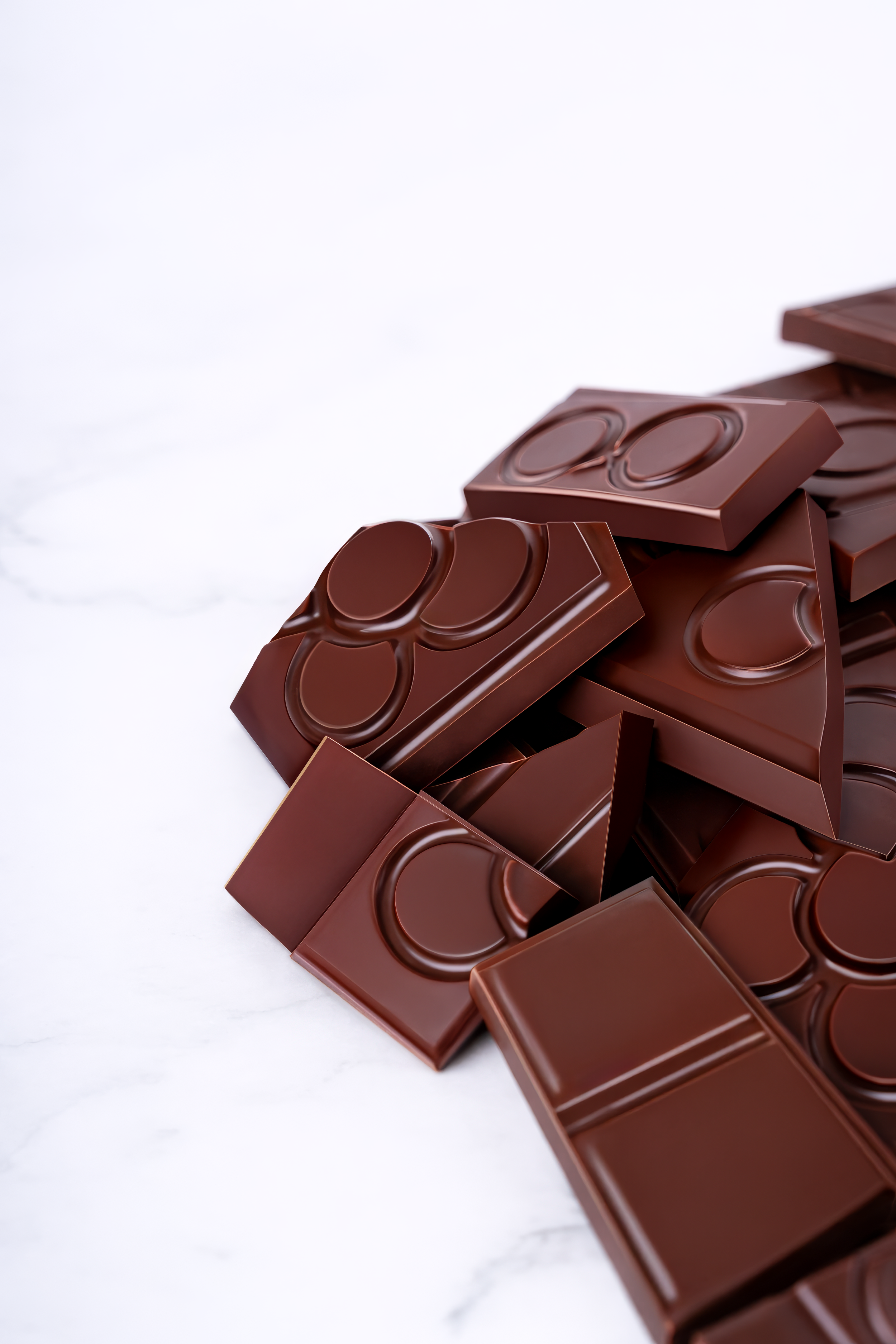 Piezas de chocolate oscuro en una superficie blanca.