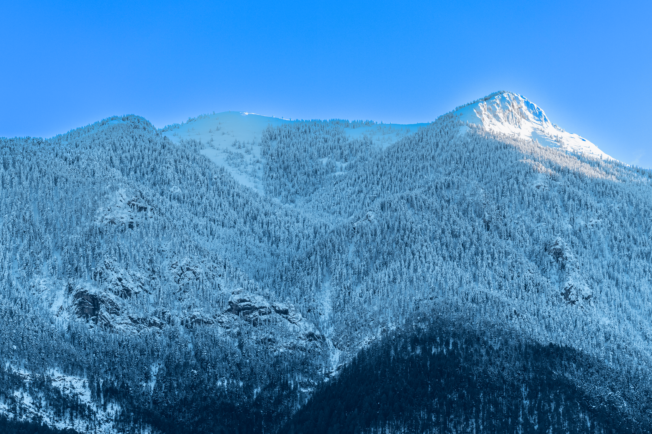 Montañas cubiertas de nieve con un cielo azul claro.