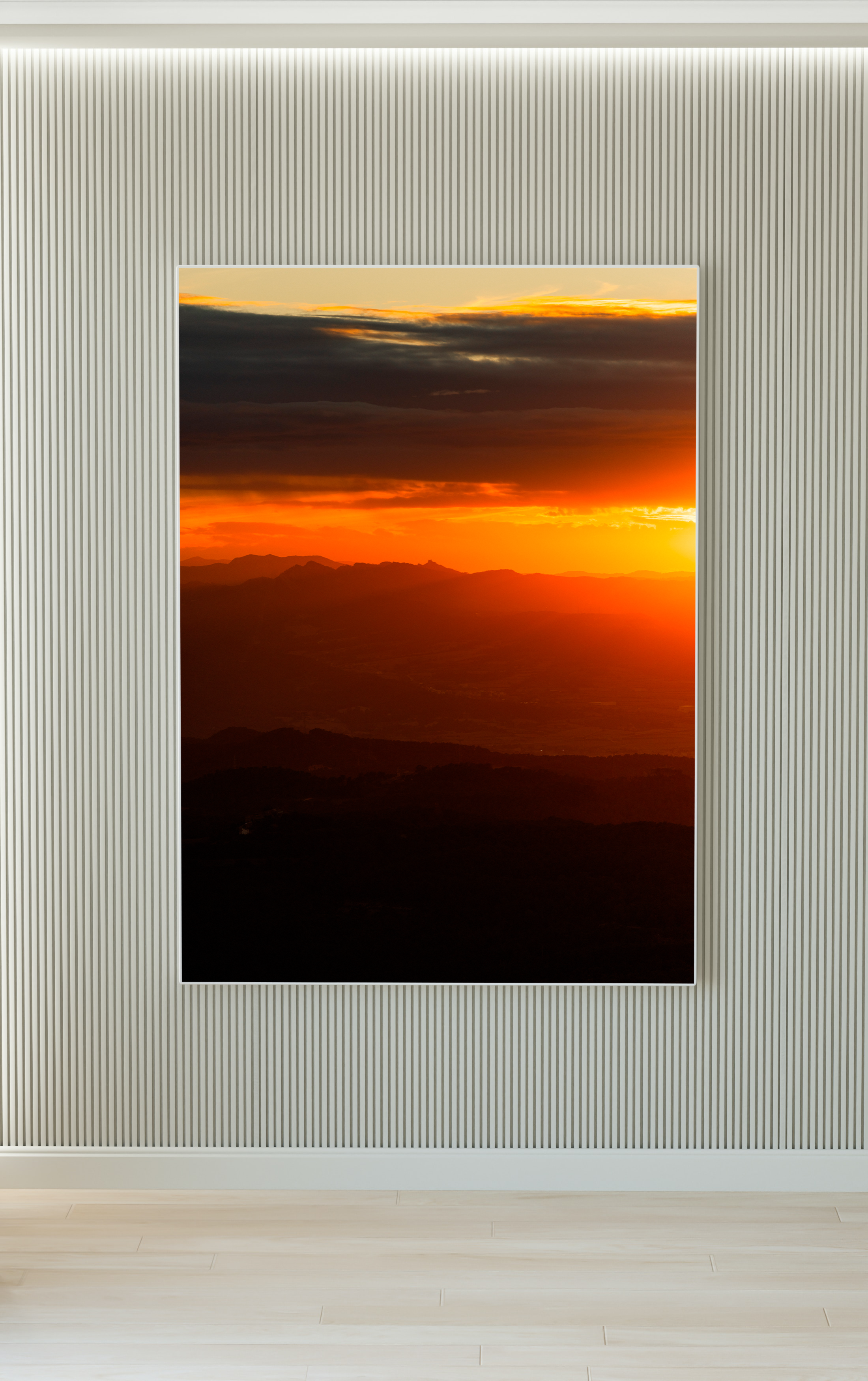Pintura de un atardecer con nubes oscuras y un cielo naranja enfrentado en una pared de fondo con textura lineal en una habitación moderna.