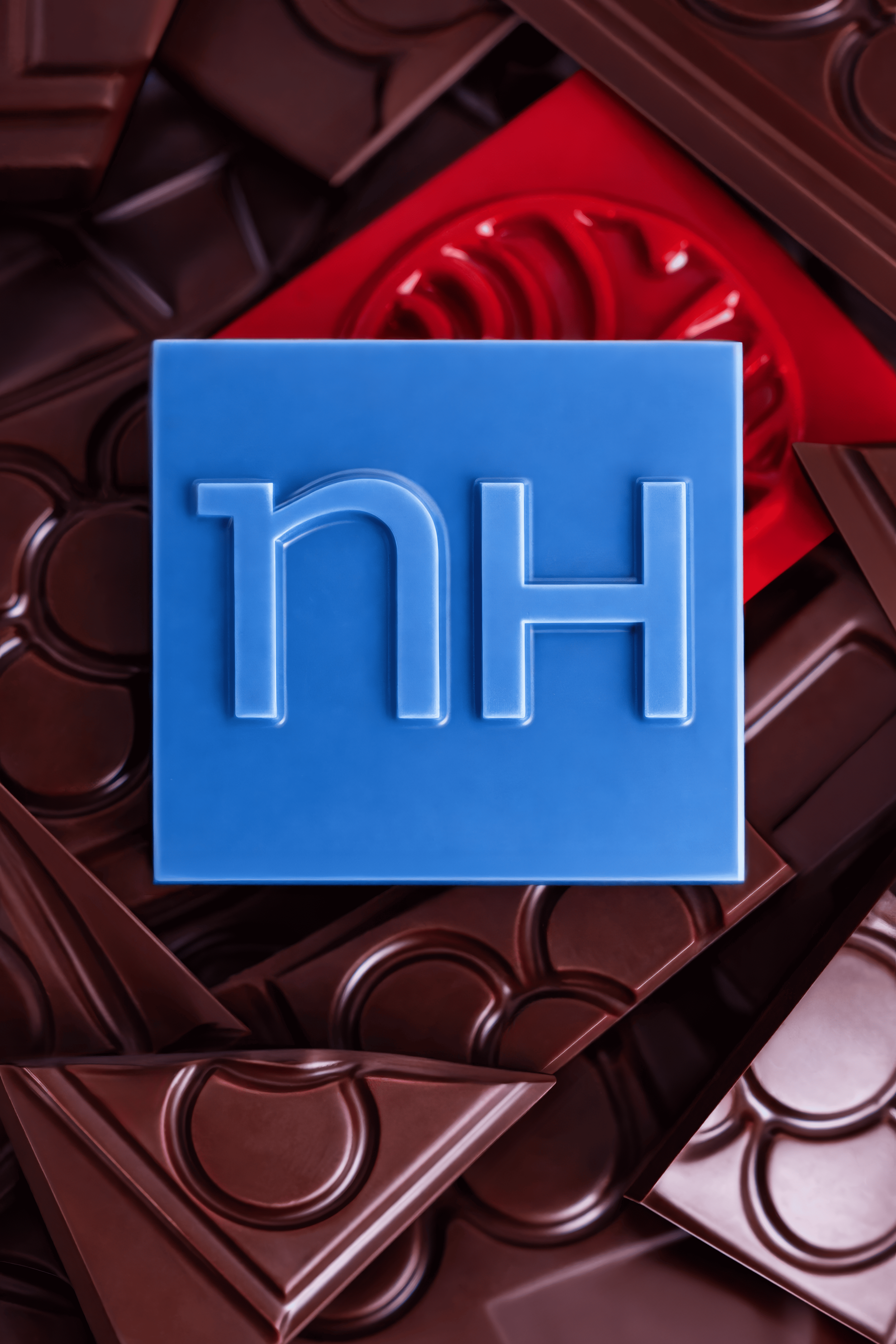 Cubos de chocolate con una pieza azul en forma de un bloque de chocolate con la letra 'H'.