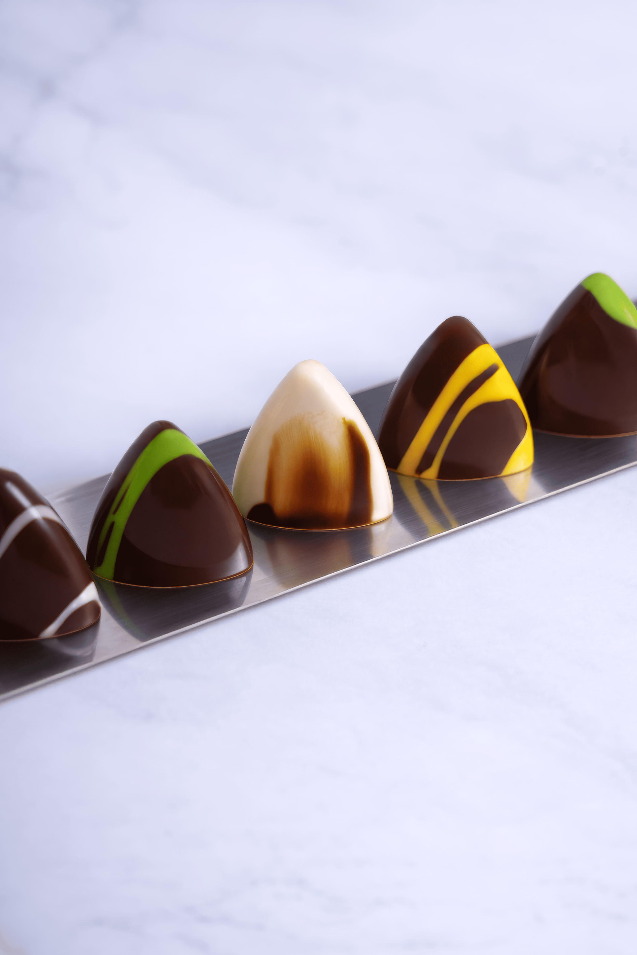 Selección de bombones de chocolate decorativos en una bandeja de metal