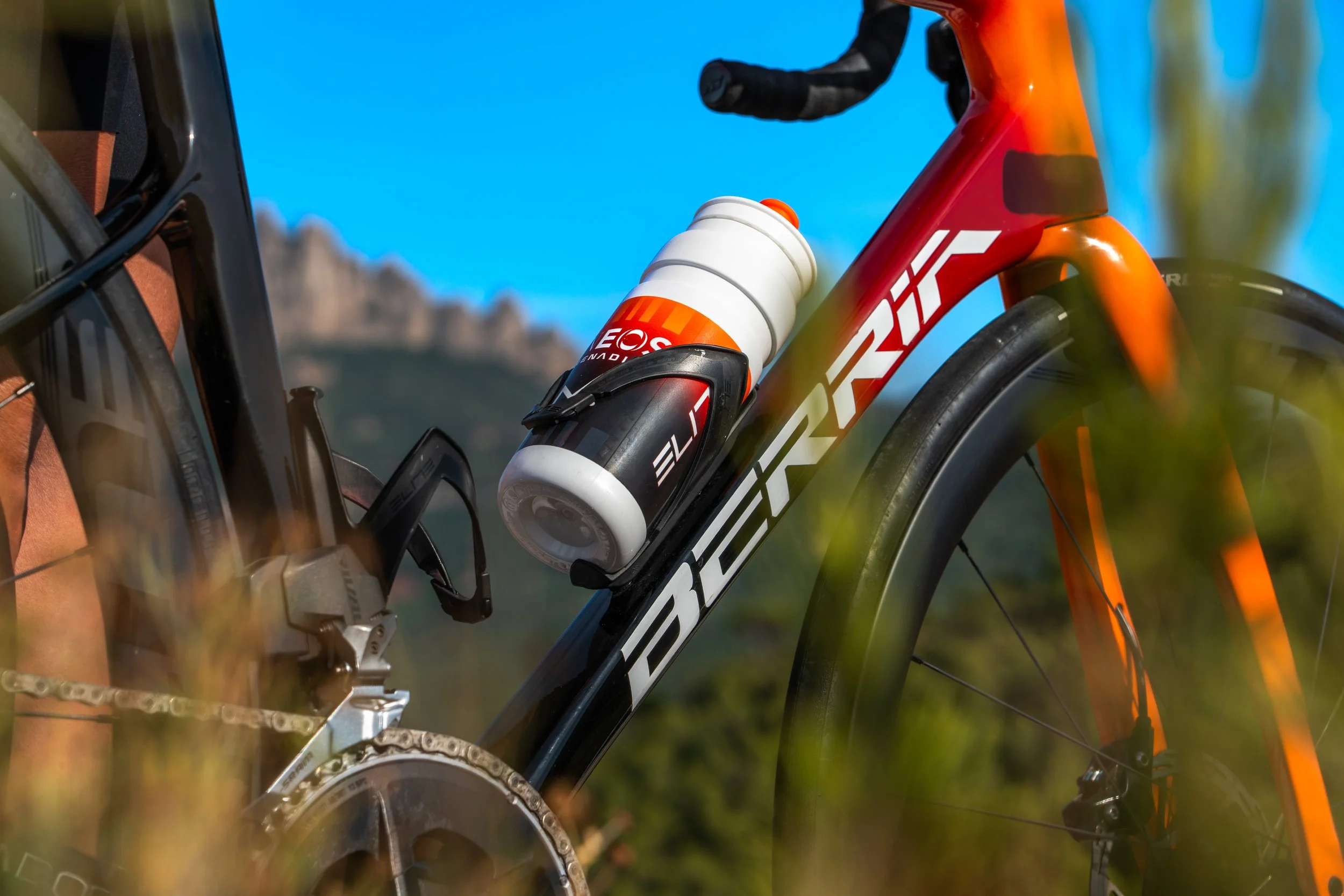 Bicicleta de senderismo con botella de agua en el cuadro delantero, en un entorno natural.