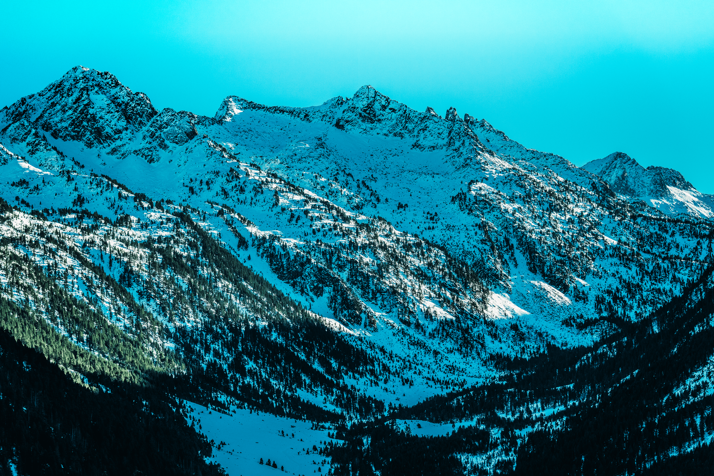 Montañas nevadas con picos altos y un cielo azul claro