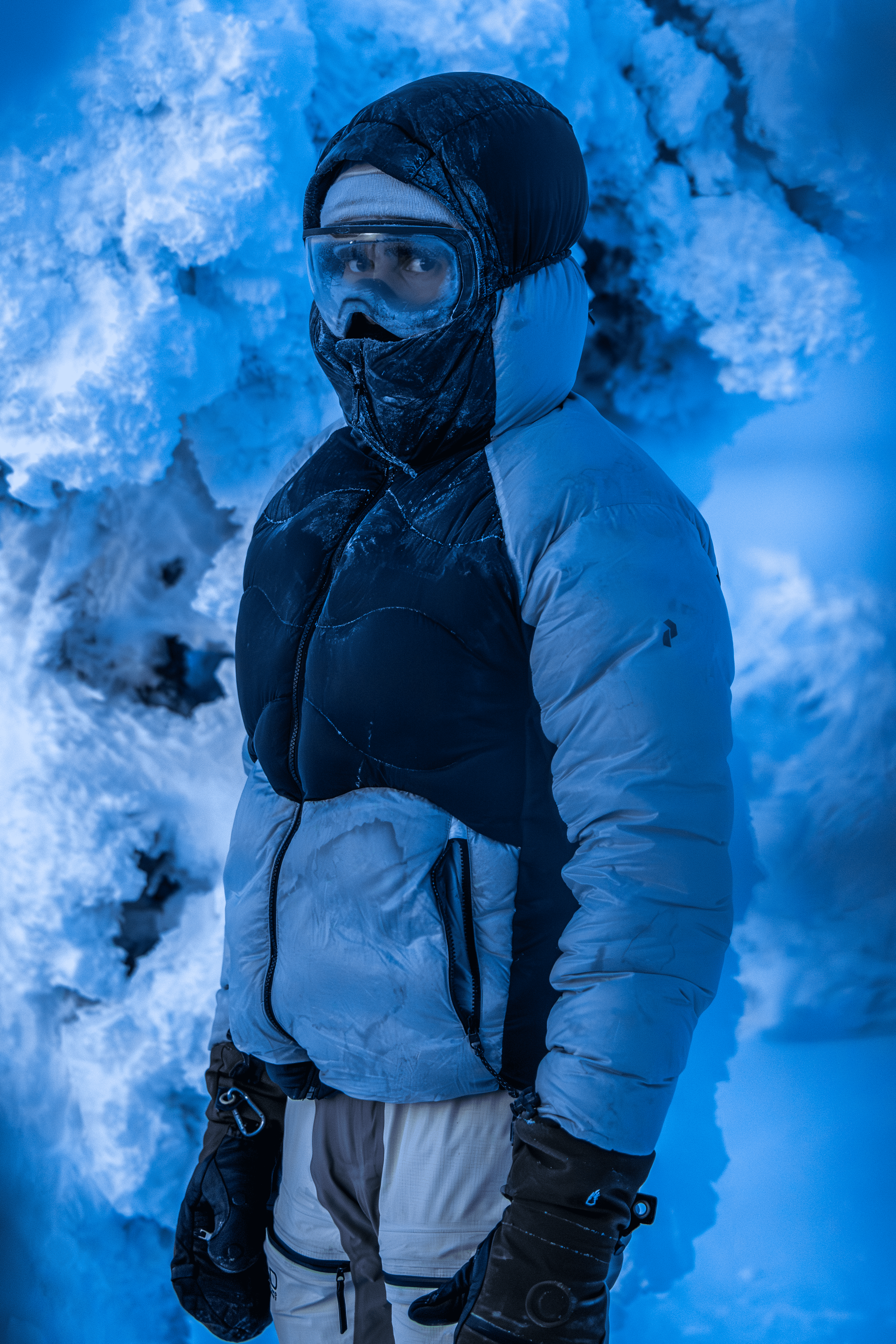 Persona vestida con ropa de abrigo en un paisaje nevado, usando gafas y bufanda