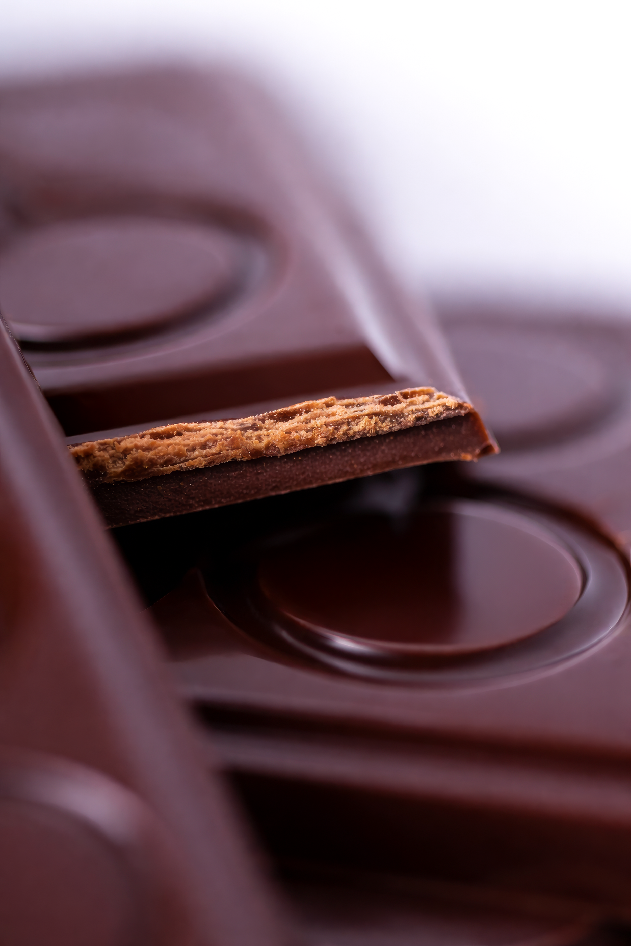 Chocolate con leche en tabletas, con una ficha rota que muestra la textura interior.