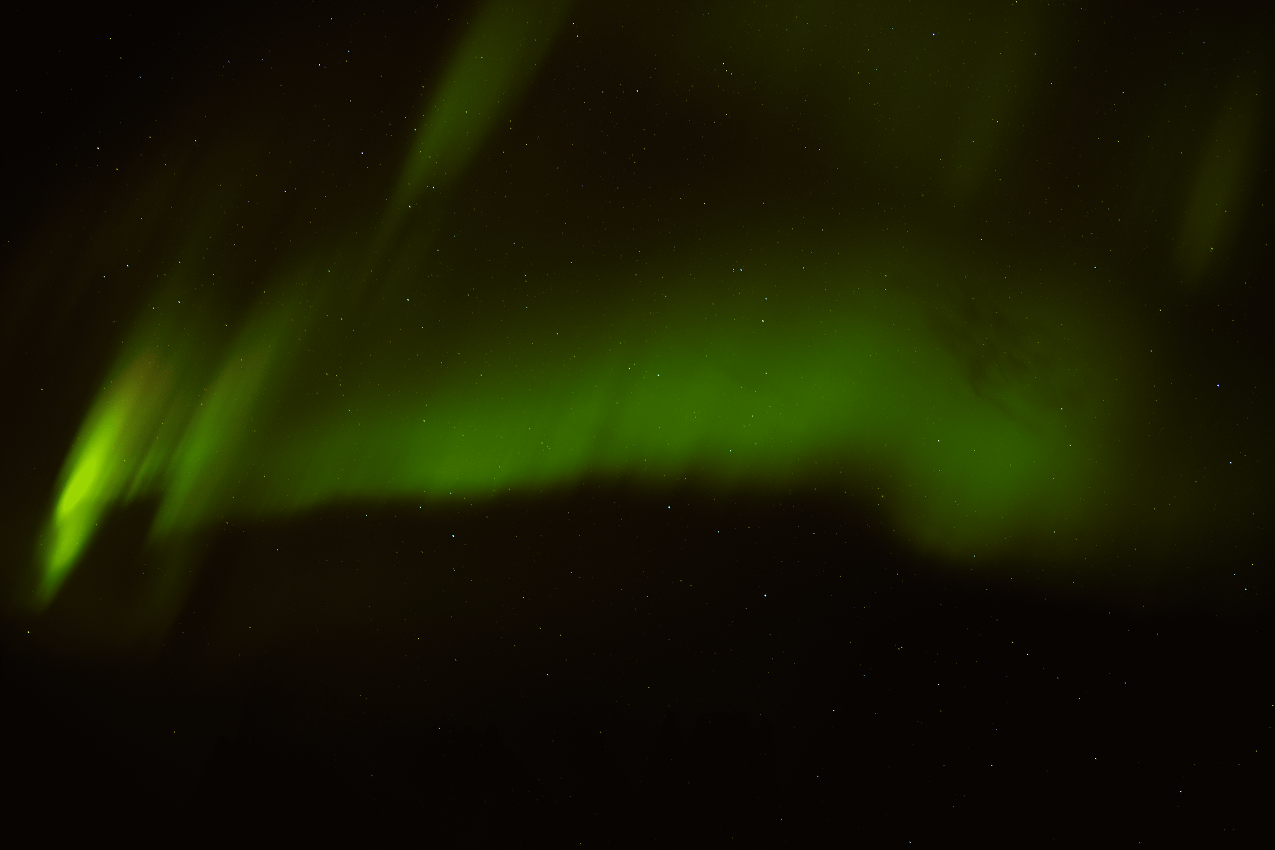 Aurora boreal verde en el cielo nocturno con estrellas.