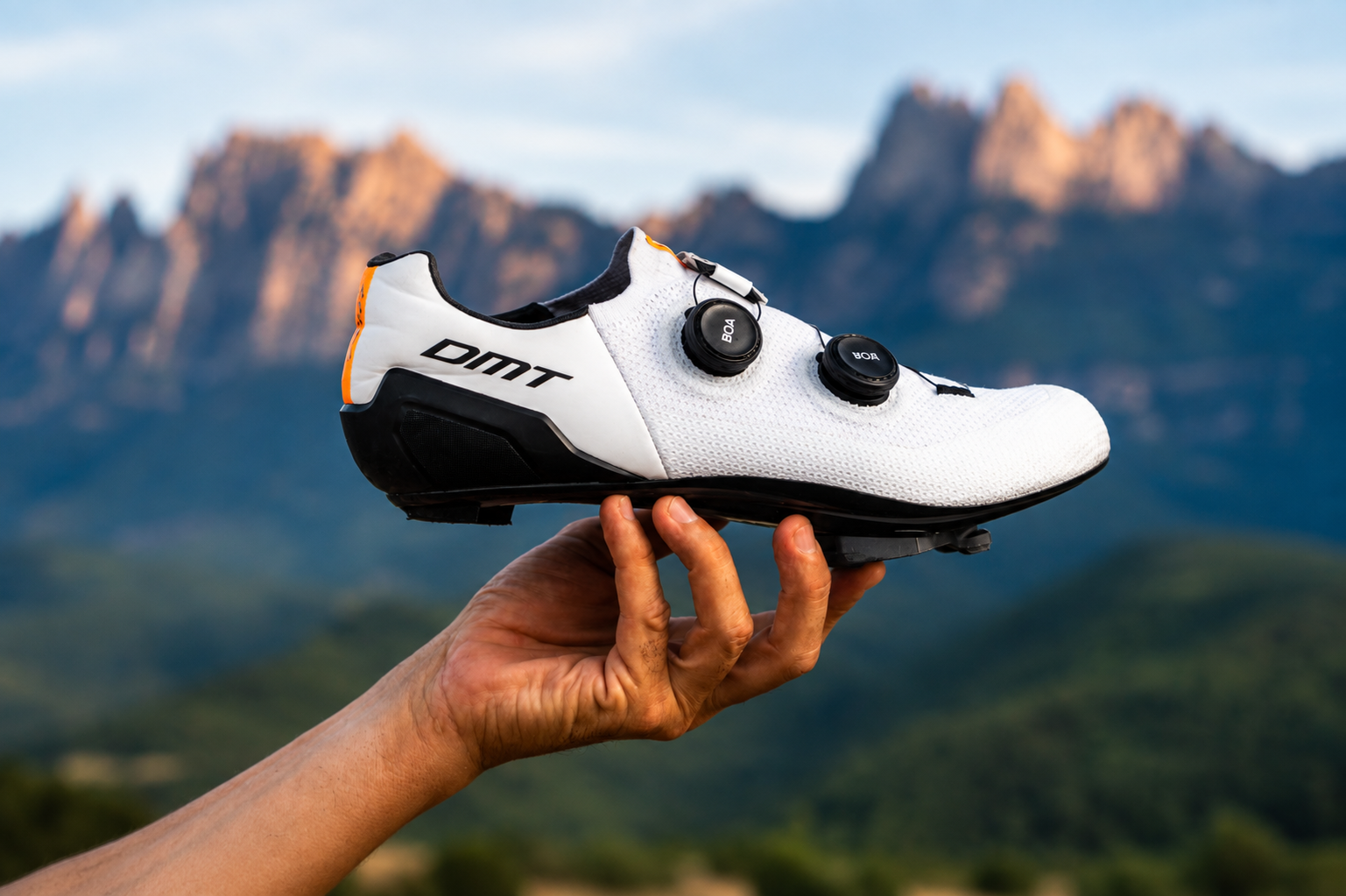 Zapato de ciclismo con cierres de rosca en un fondo montañoso.