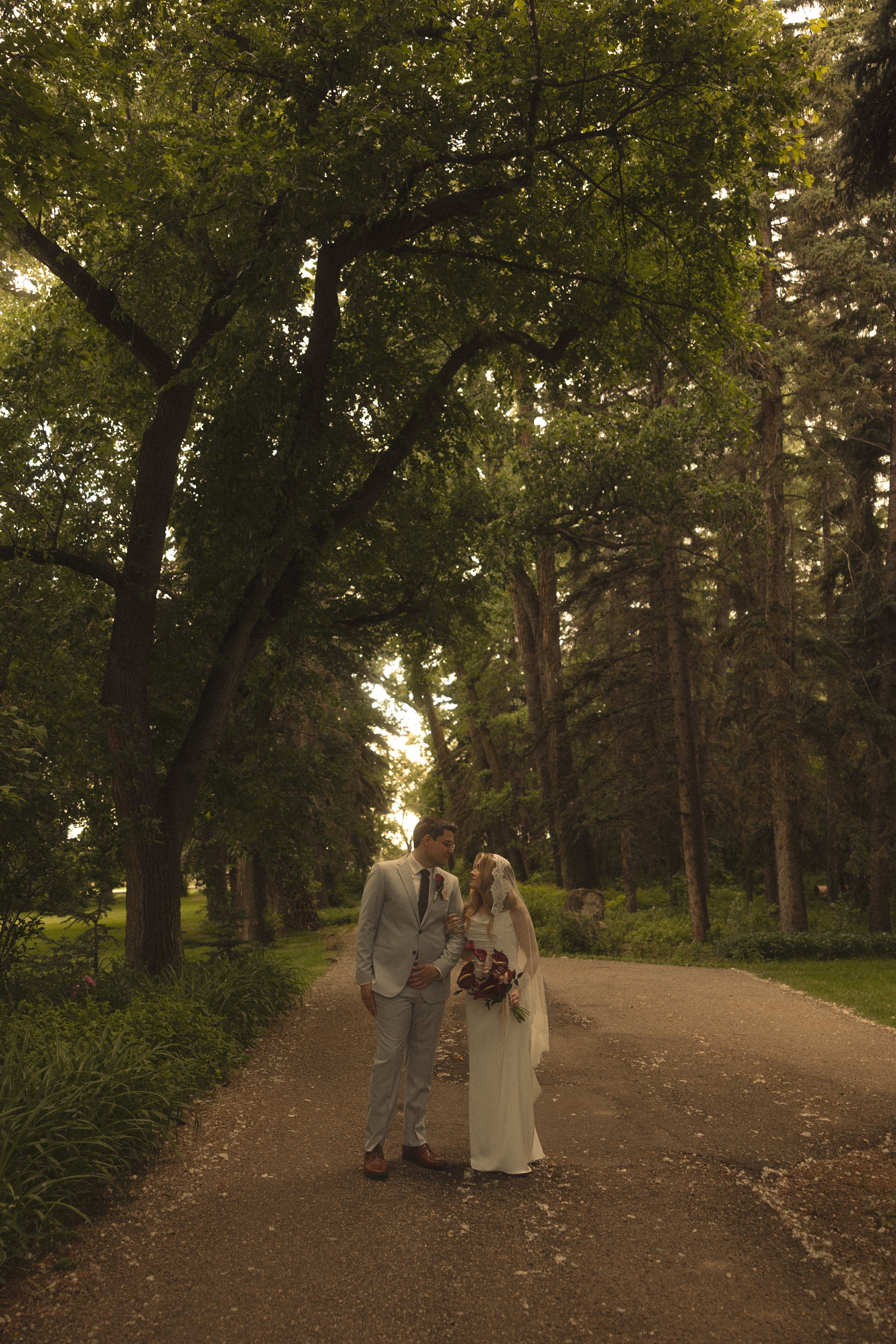 bride and groom at the norland historic estate walking down the path with trees surrounding them