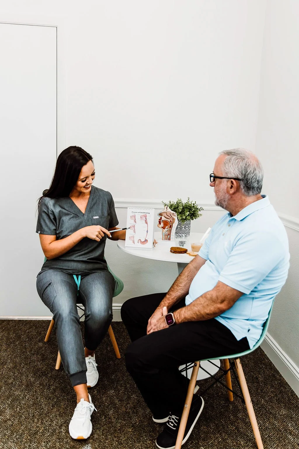 woman sitting with a man and pointing at a picture with a