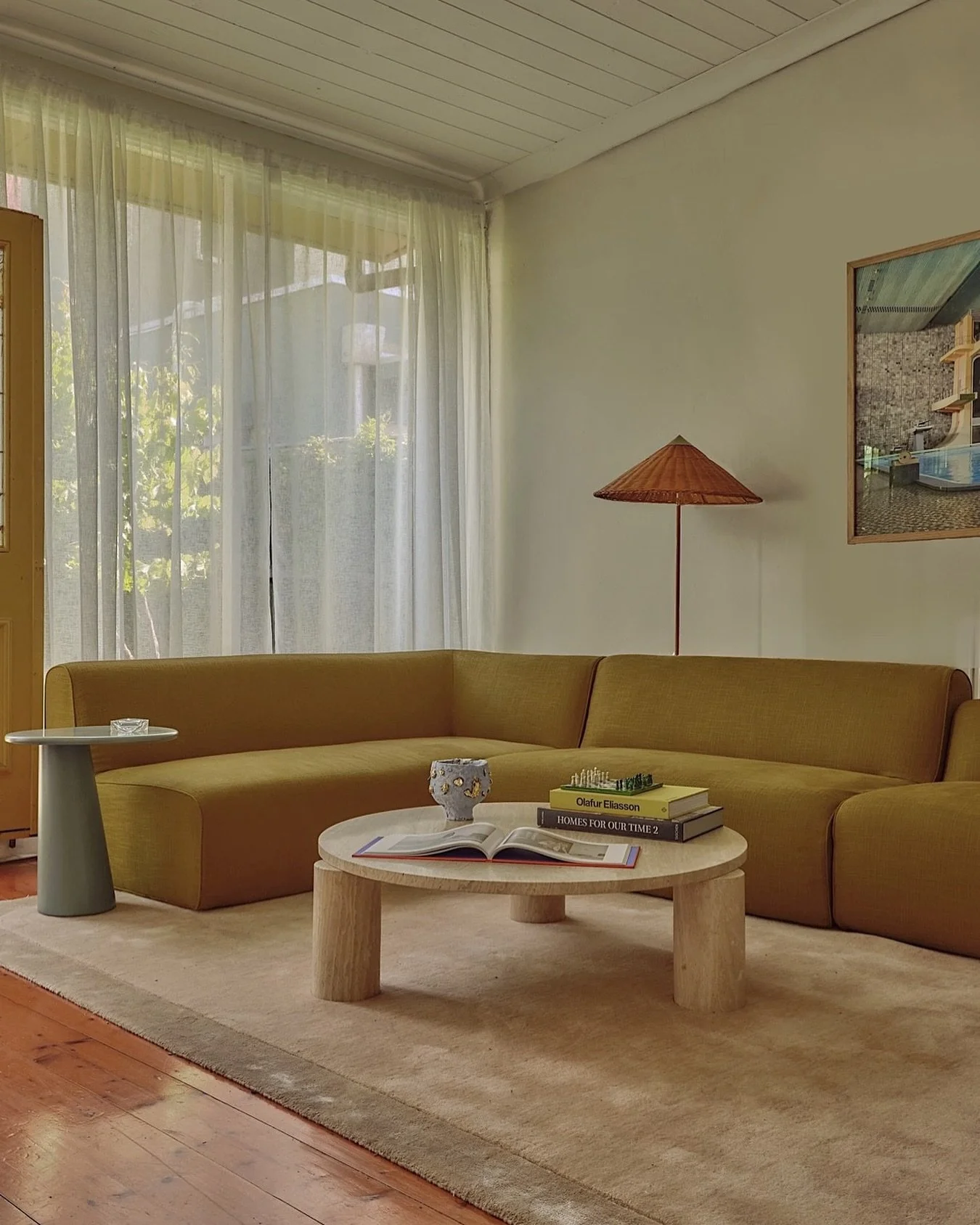 Revisiting The Stables living room, one year after we photographed the project. 

We anchored the room with a reupholstered modular sofa in citron - a punchy choice that works because of everything around it. Sheer curtains and a plush rug soften the