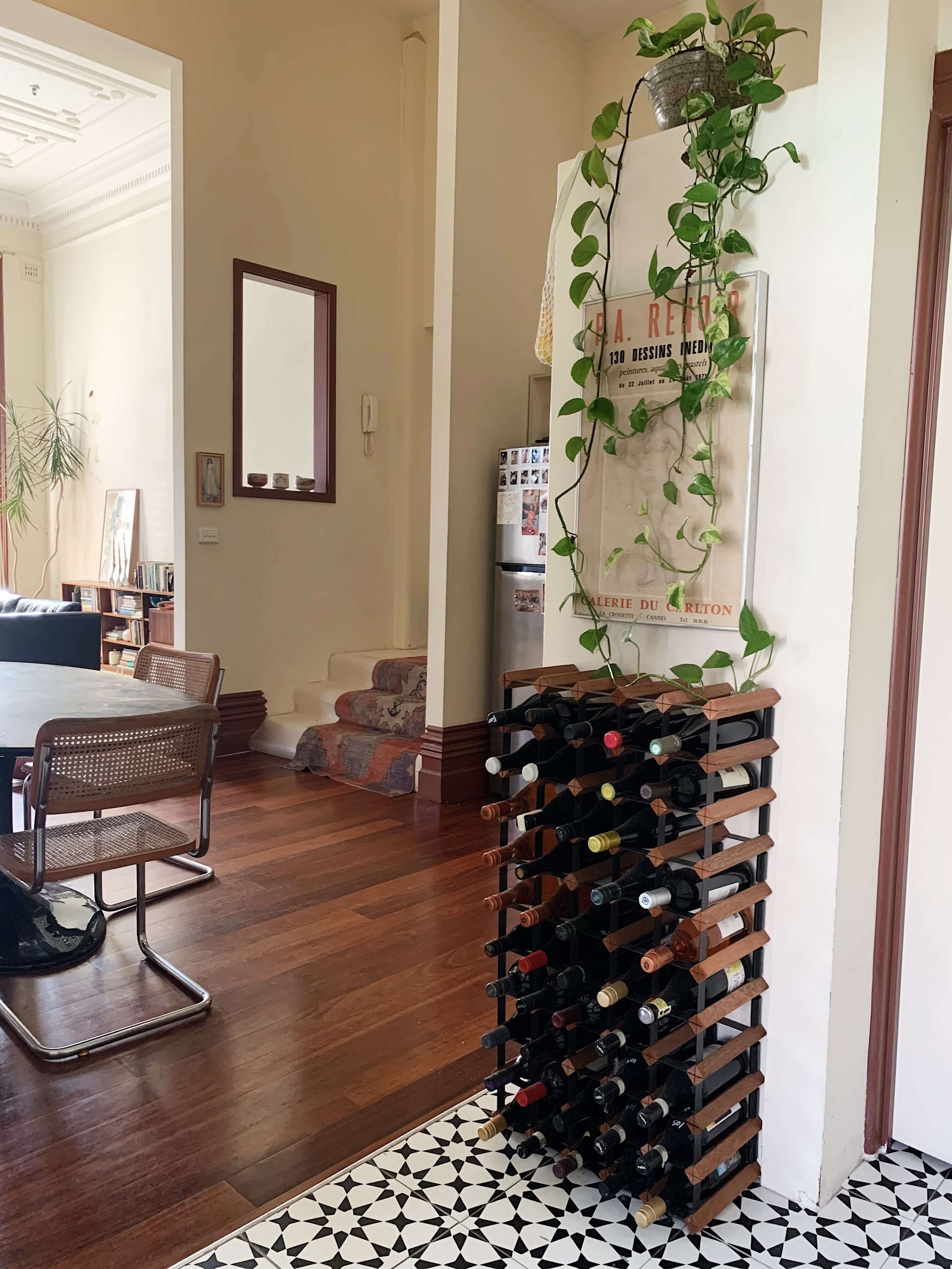 Stylish wine rack and art display in a modern kitchen setting by Alyssa Owens Design. Japanese ceramics on display in the background.