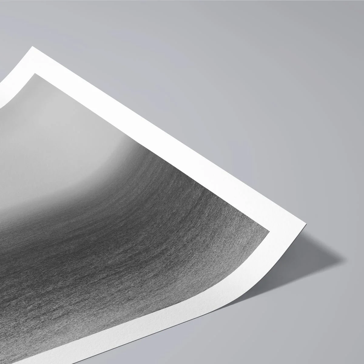 Detail of a black and white fine art photo print gently rolled, highlighting the thickness and texture of premium matte art paper.
