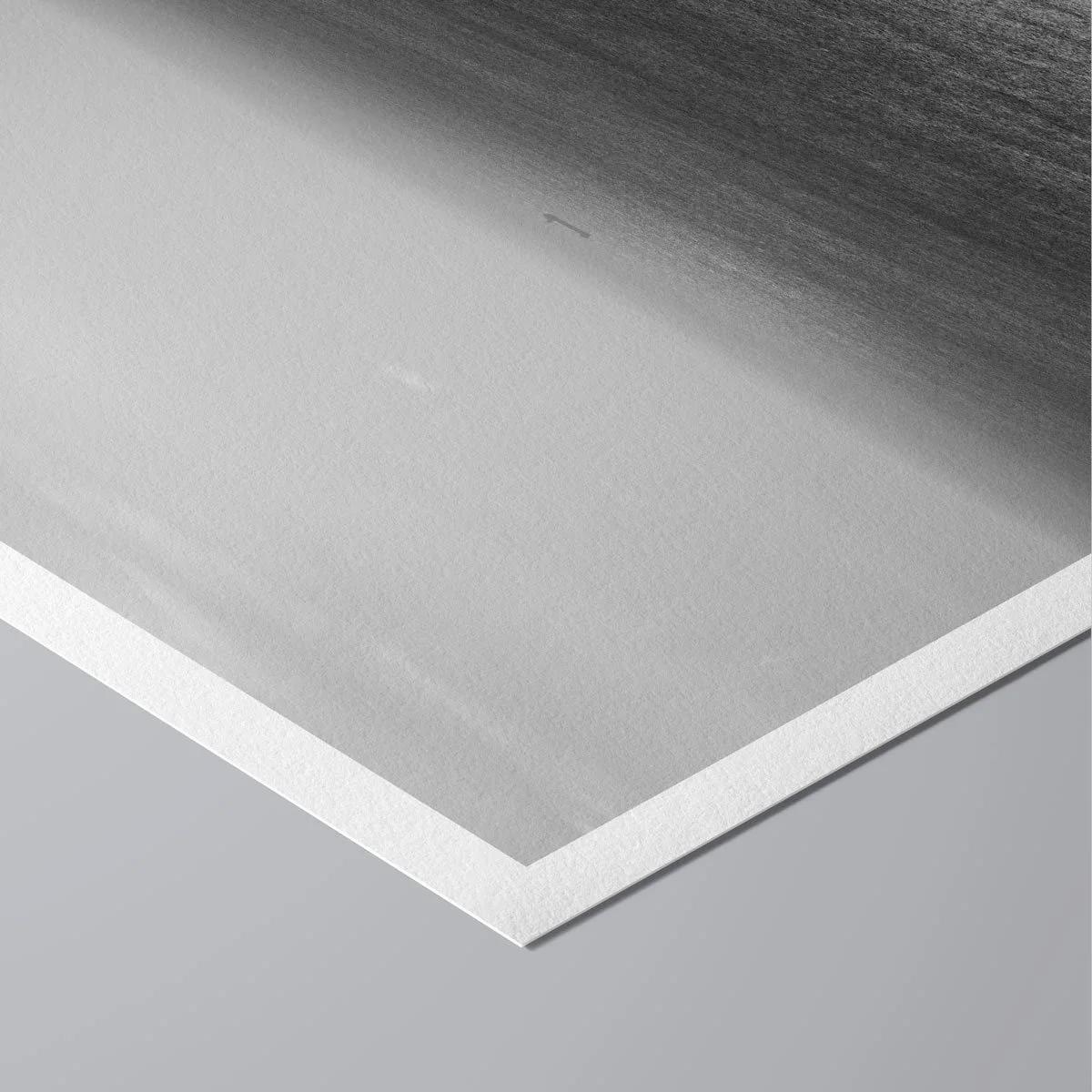 Close-up of a fine art black and white photography print on textured matte paper, held by hand, showing a foggy sea and distant ship.