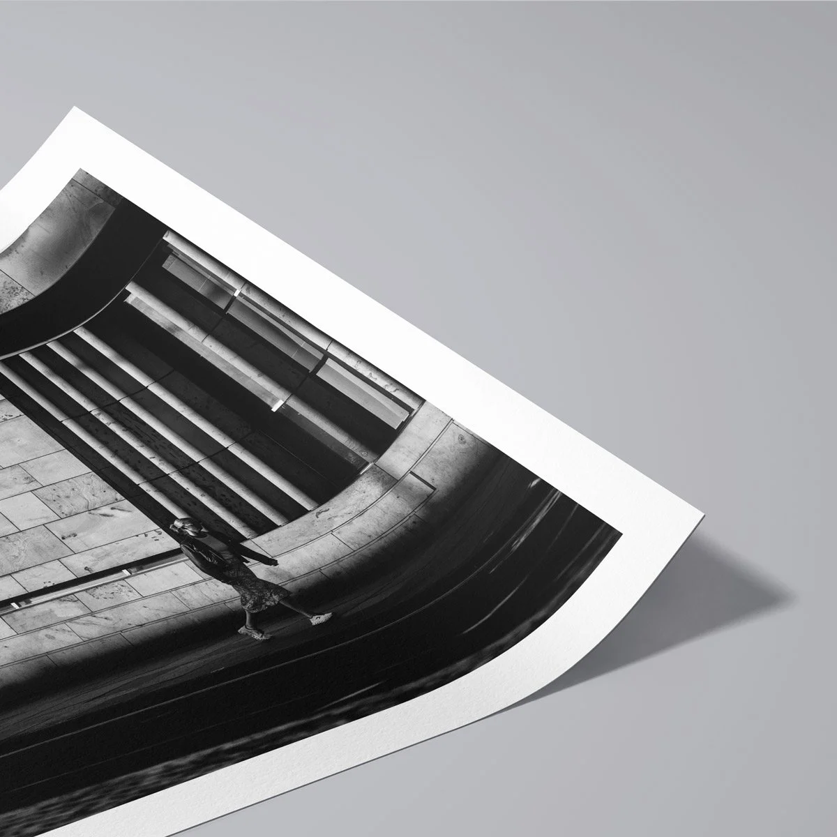 Solitary person walking through an urban architectural environment in black and white