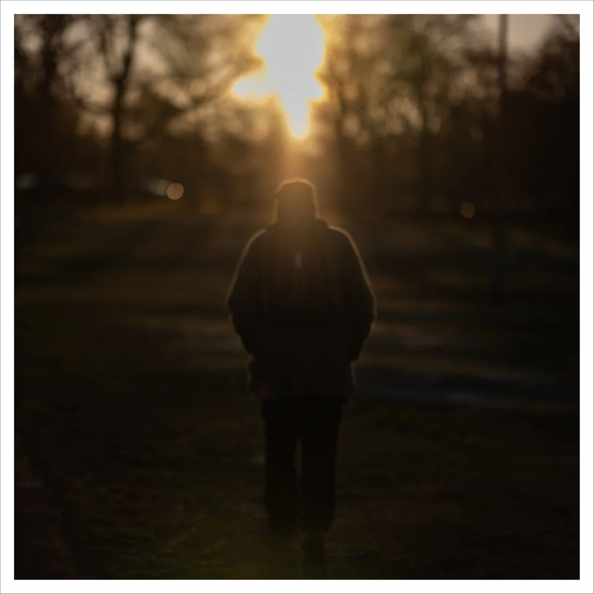 Full image view of PASSER, a fine art photograph of an anonymous figure crossing Edinburgh Meadows just before sunset.