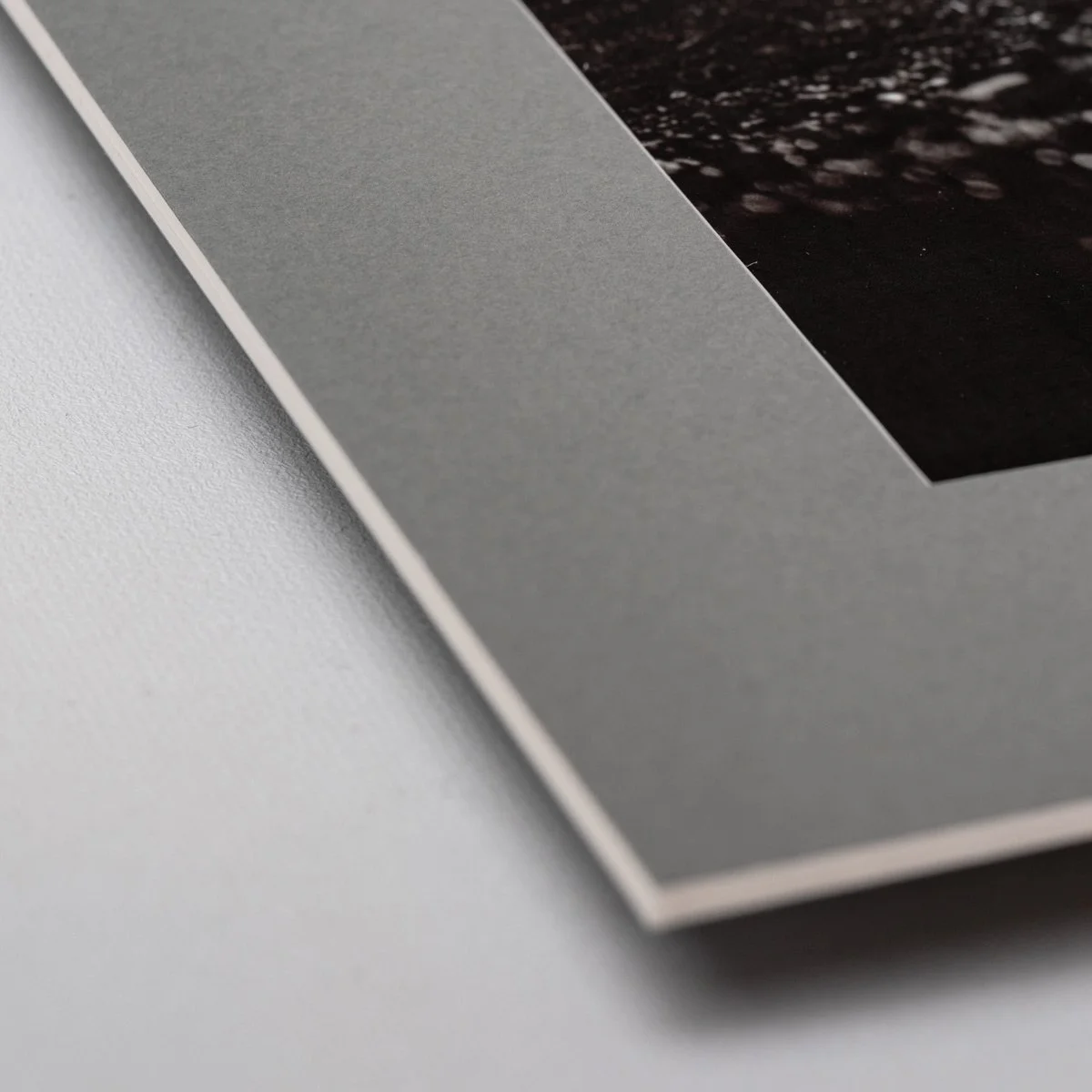 Angled close-up of monochrome fine art photograph on bamboo paper, highlighting texture, tonal depth and minimal presentation