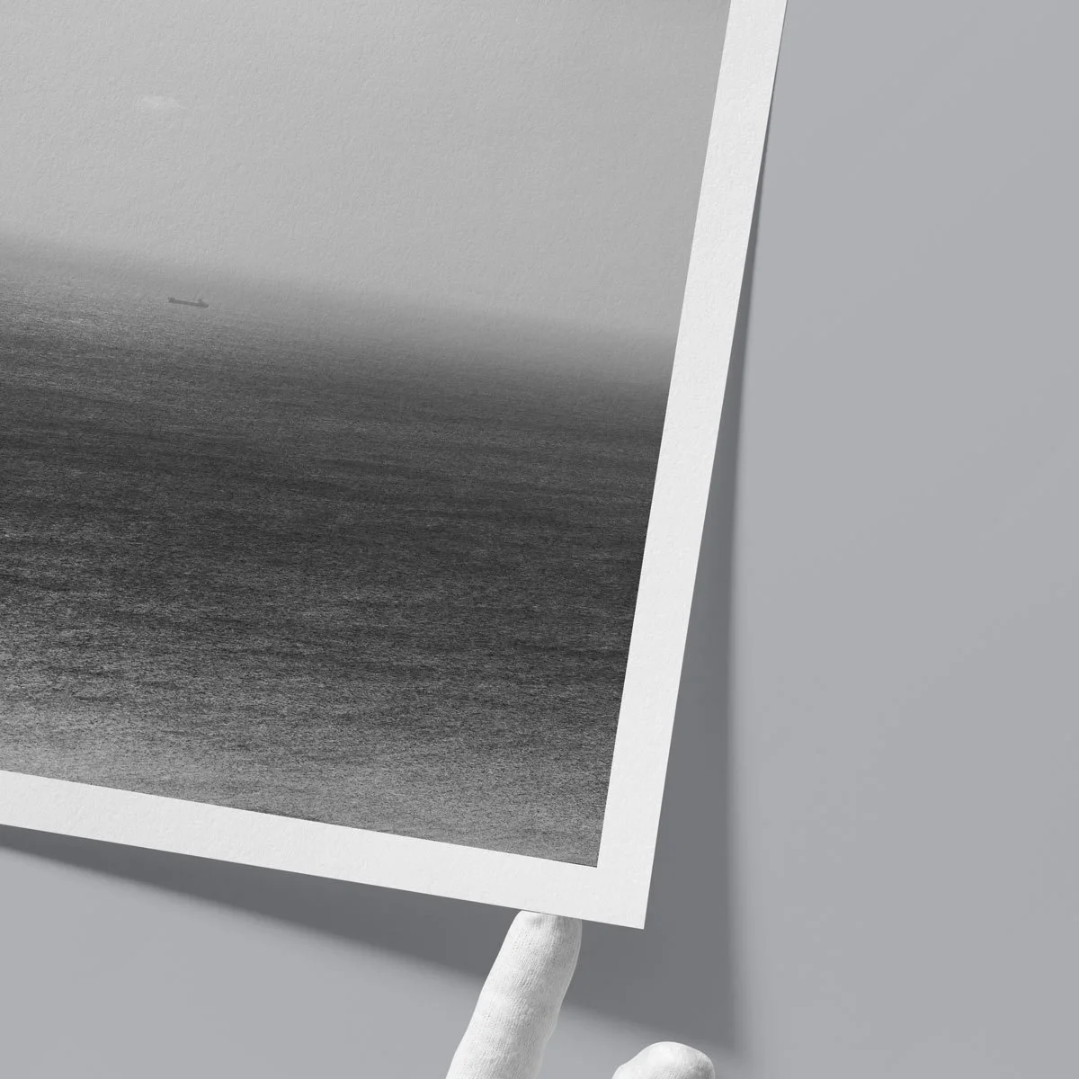 Upside-down view of a black and white seascape fine art print, revealing subtle grain, tonal transitions, and textured art paper surface.