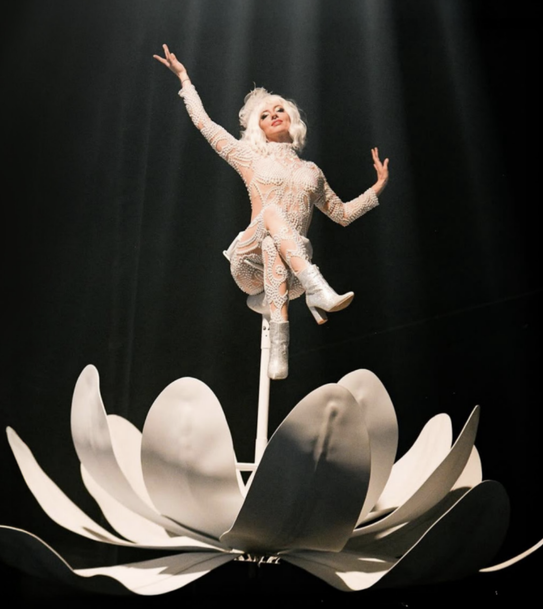 Sway Pole Aerialists sits on a flower