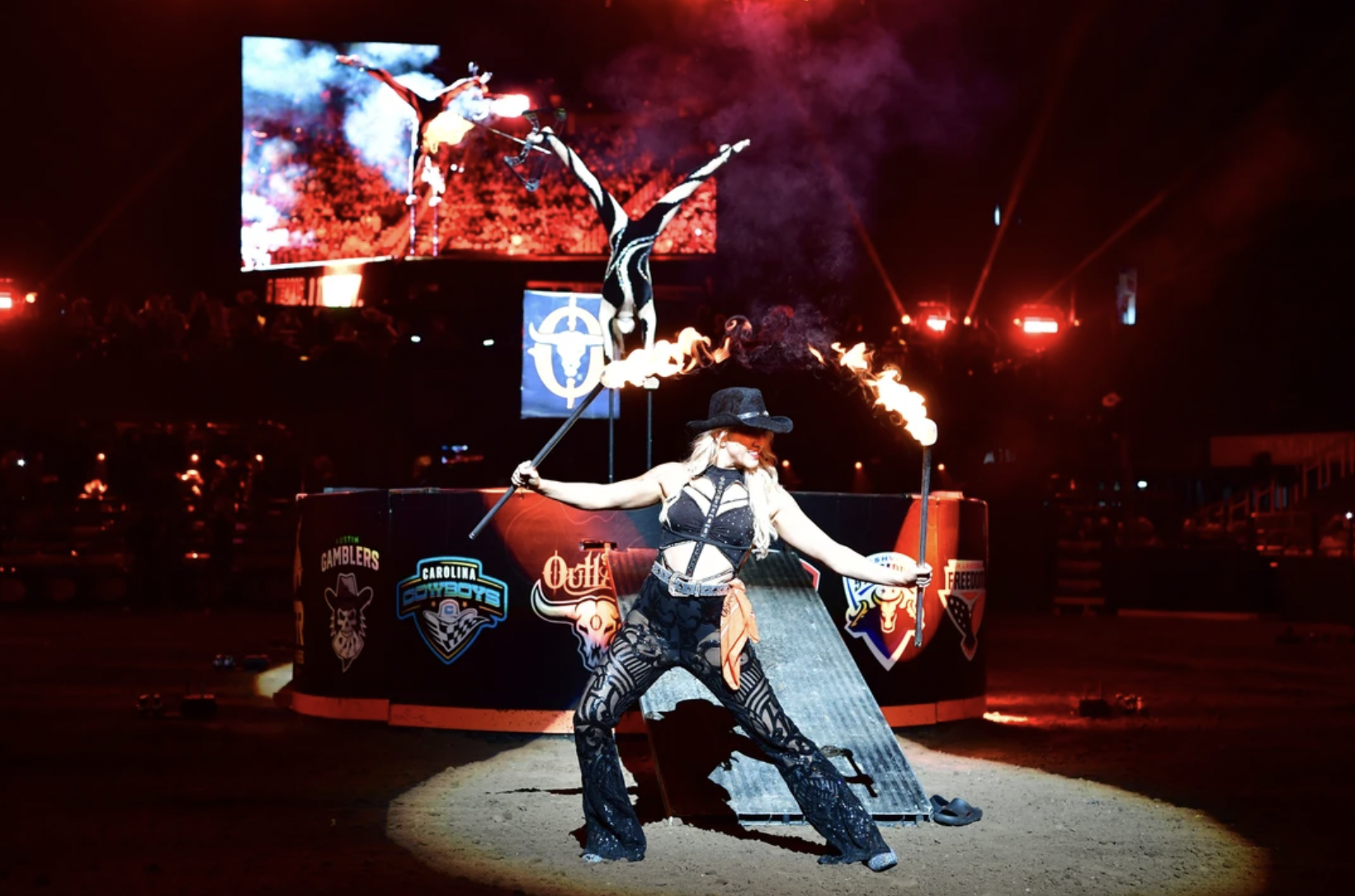 Performer at a rodeo with fire sticks