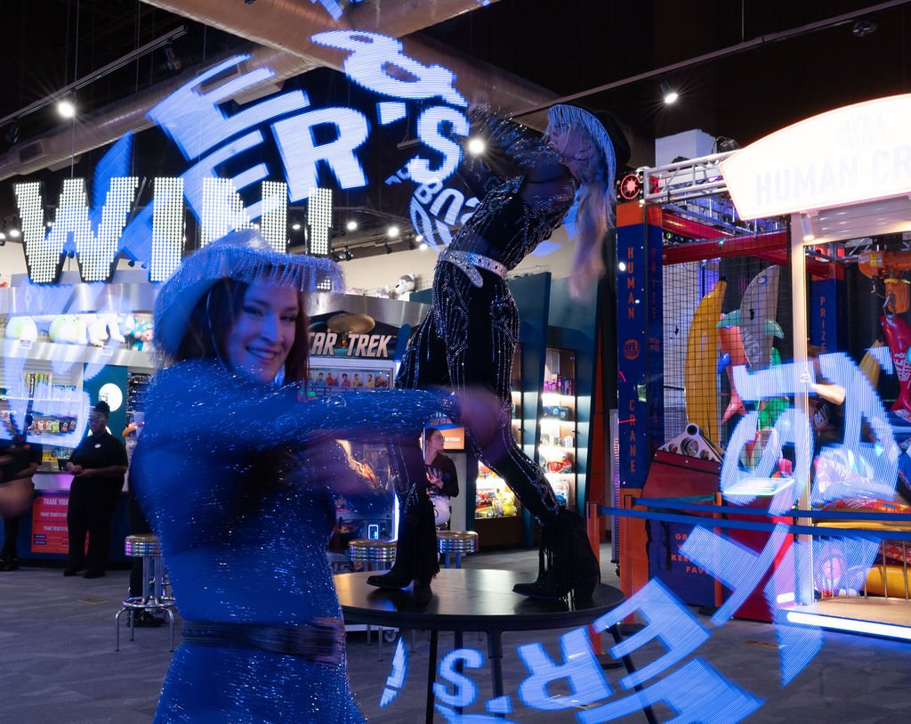 Custom LED poi performer displaying the Dave & Buster's logo during a branded corporate event activation