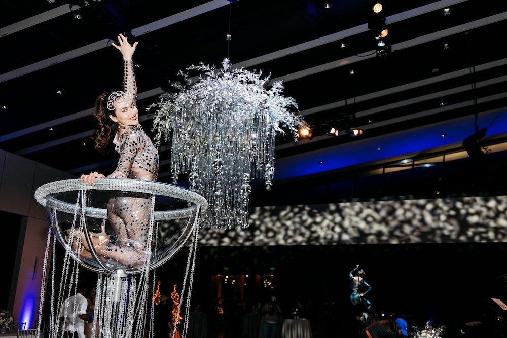 Contortionist performing in a giant martini glass at a corporate holiday party
