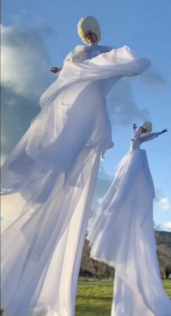 Aerial acrobatic sway pole performers in white costumes