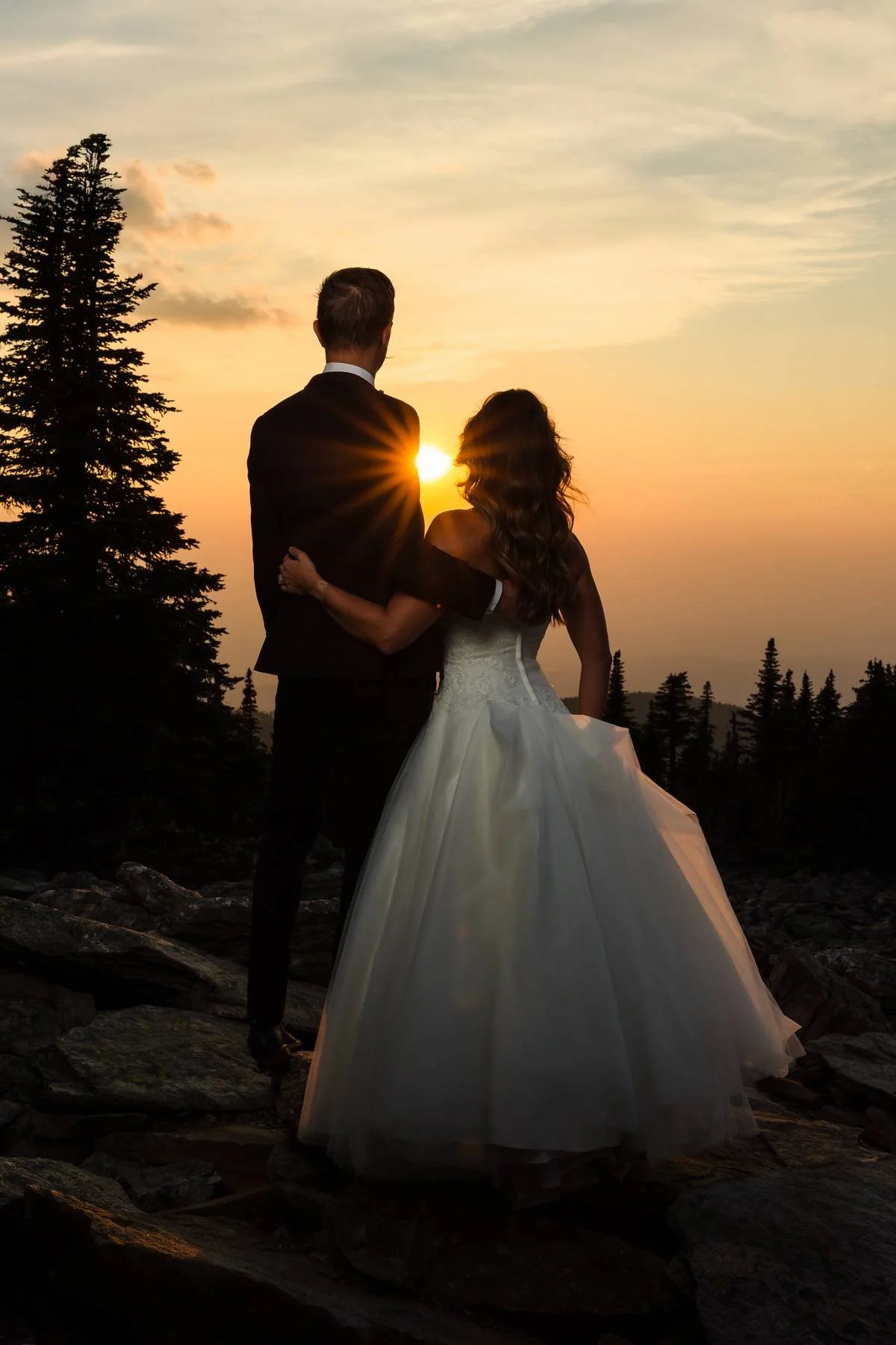 Elopement couple standing hip to hip on the top of Mt. Spokane watching the sunset.