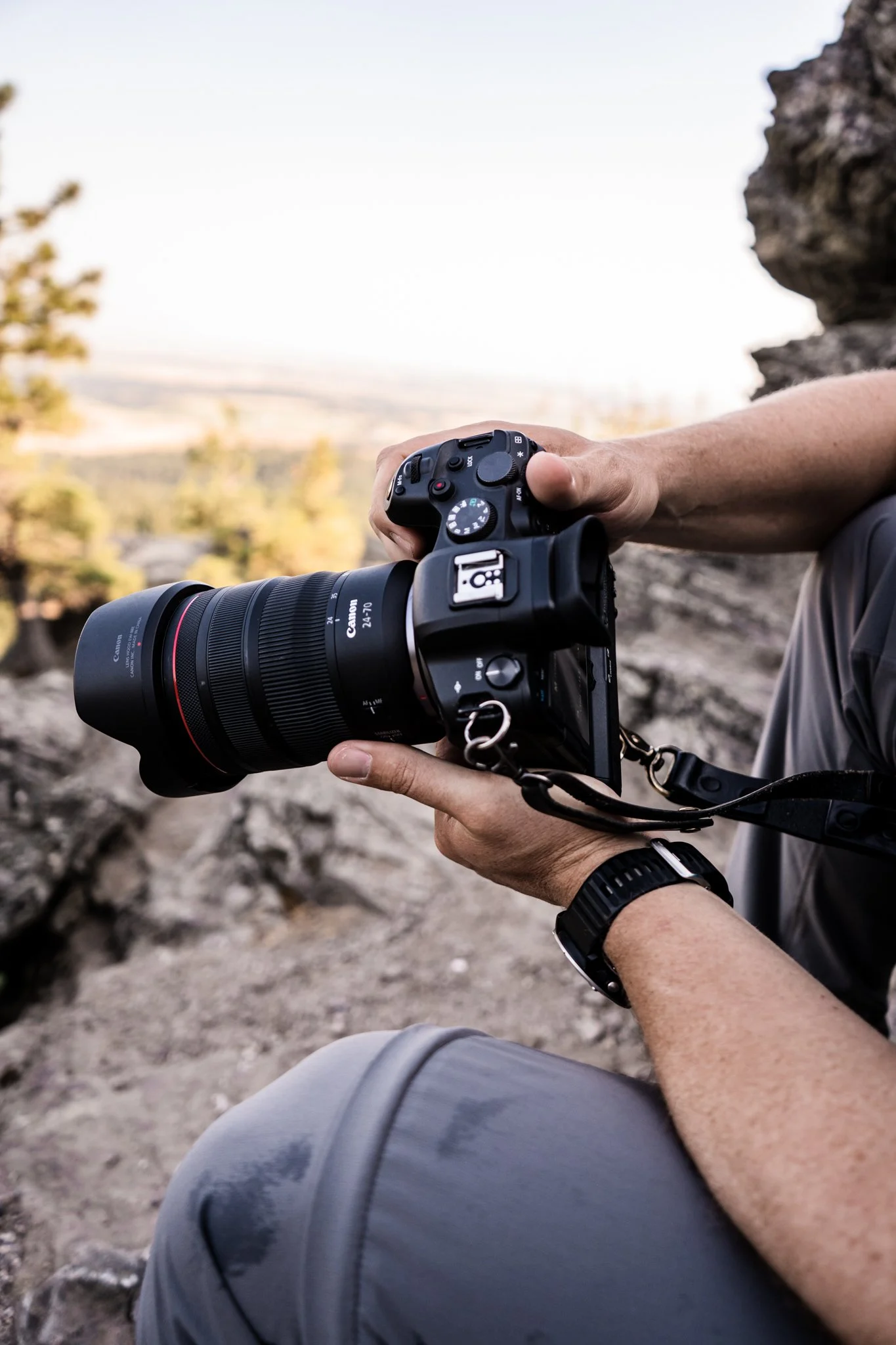 Holding a canon R6 with RF 24-70mm f/2.8 lens in a nature setting