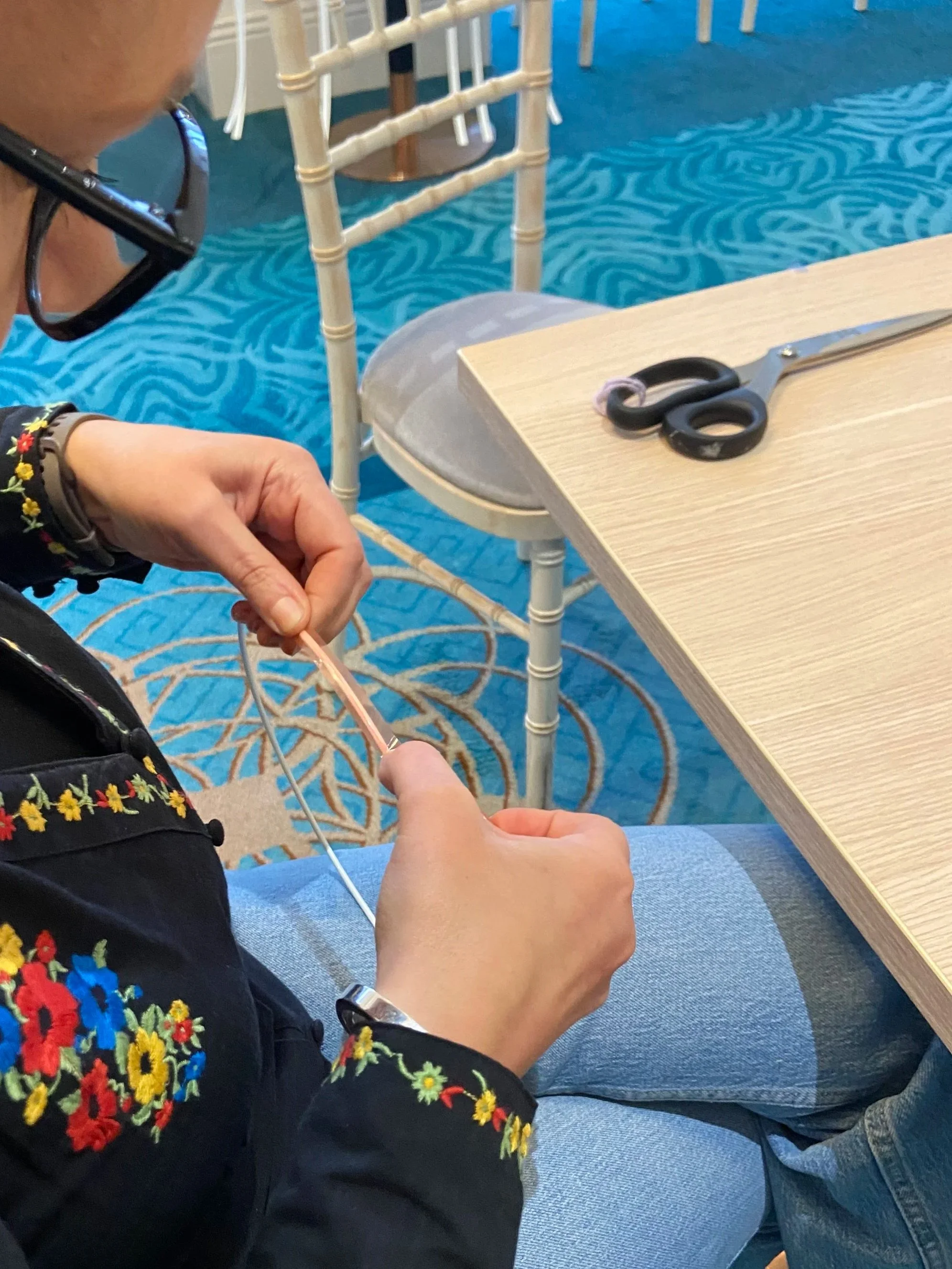 A person adding tape to  lampshade rings while attending a lampshade making workshop